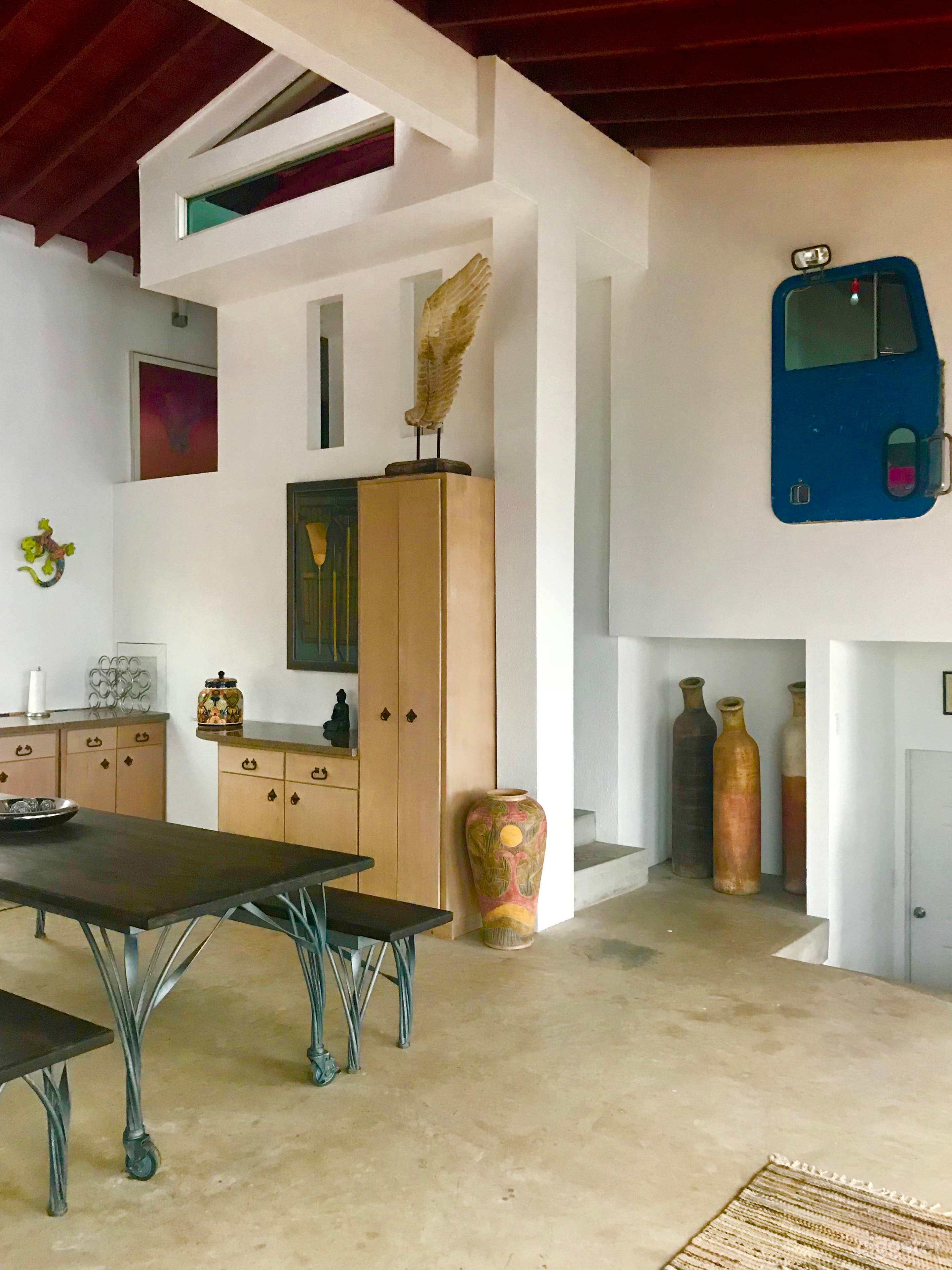 Dining Room with modular banquet table for 16.

Upcycled vintage truckdoor and rotating art gallery of original paintings and sculptures populate the communal spaces and bedrooms.