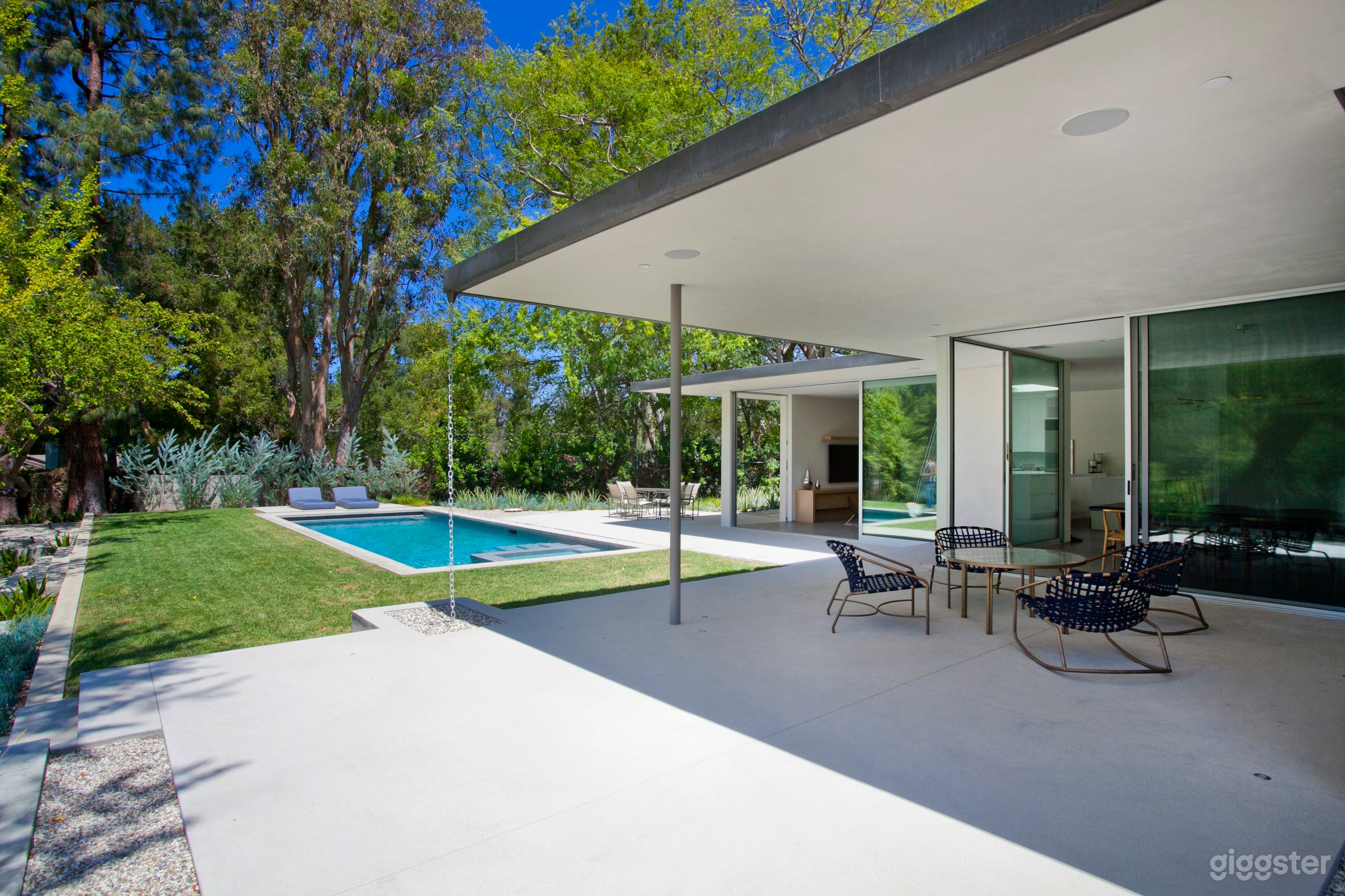 Backyard patio and swimming pool with grass surrounding
