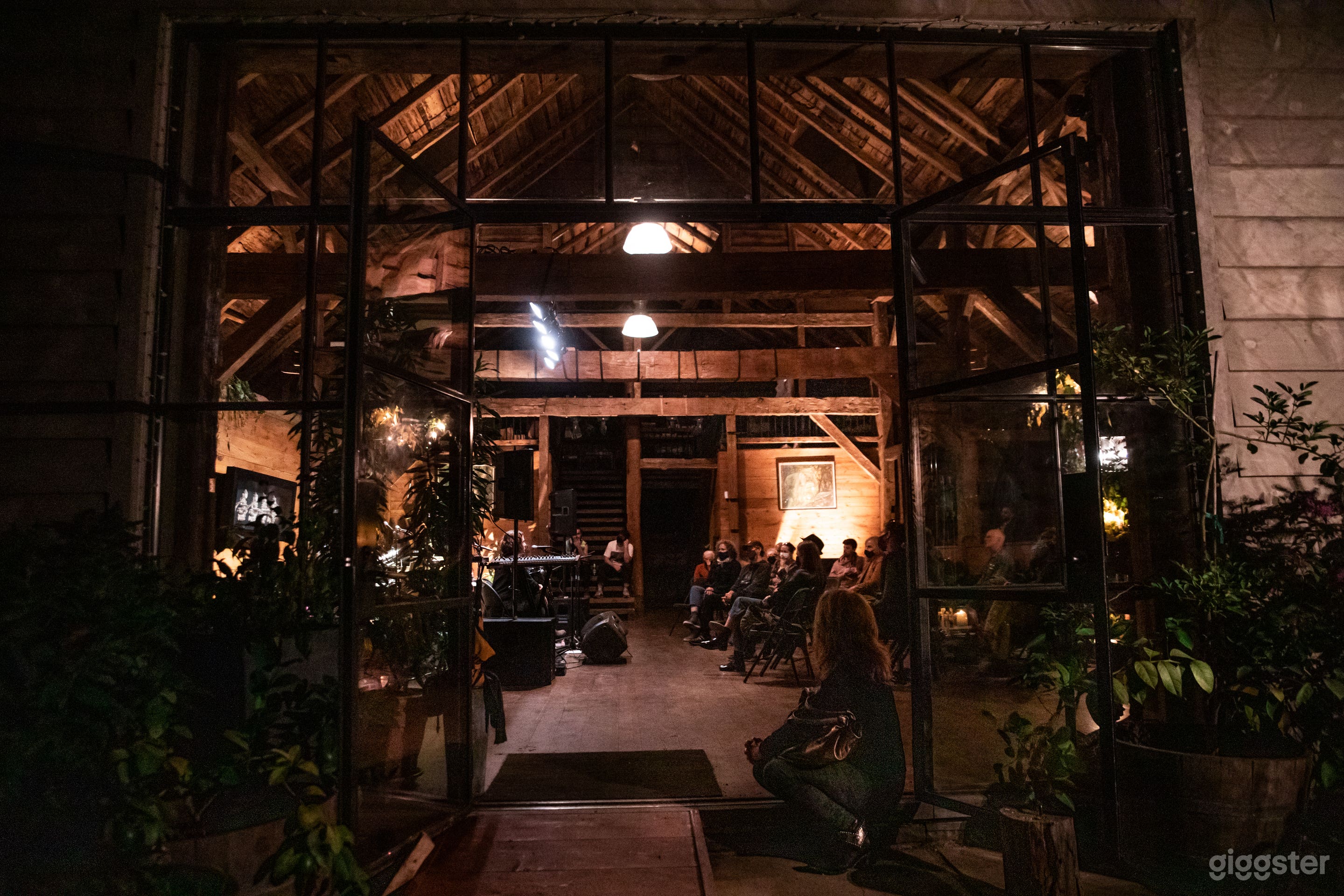 Outside, looking into a concert at the barn on a summer night 