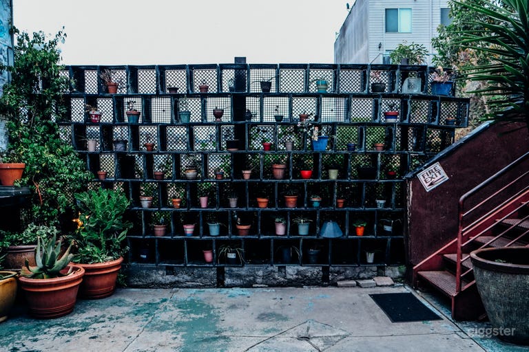  The open air patio has seating and a staircase to the green room. 