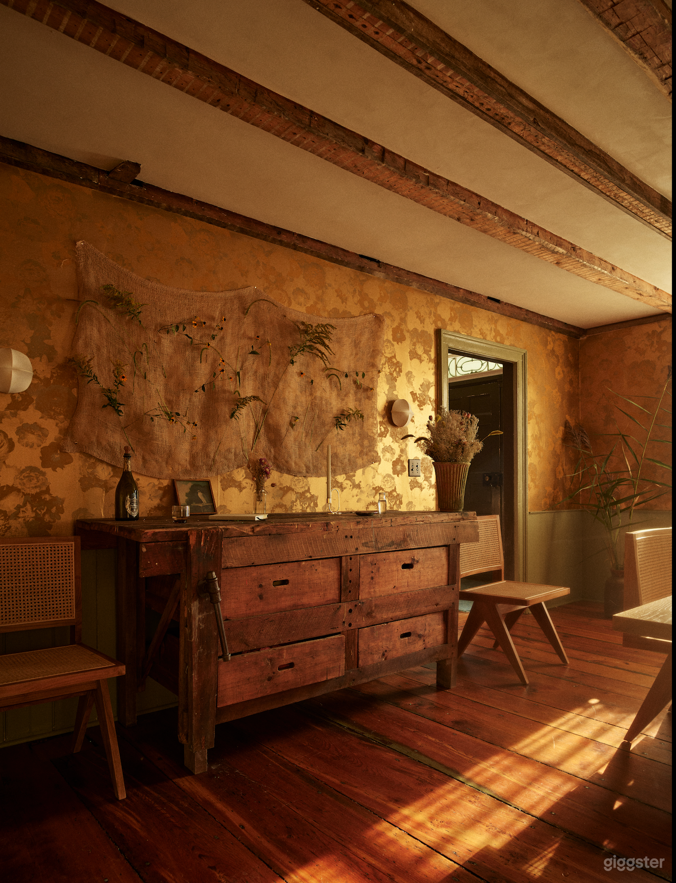 The dining room features wide, original beam floors below and above and a mix of antique and modern furnishings.