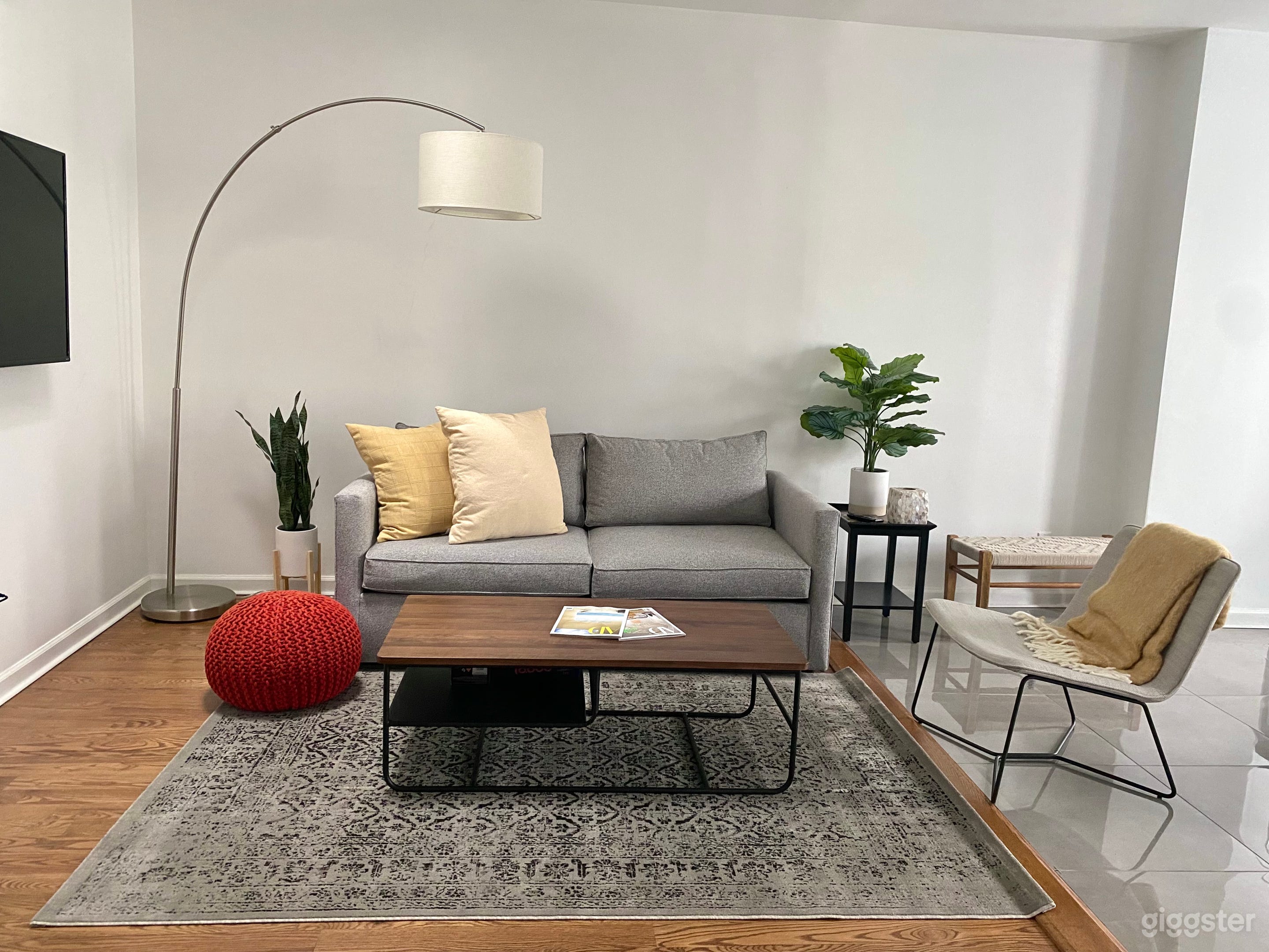 A cozy modern contemporary styled living room with tv, games and tons of natural light.