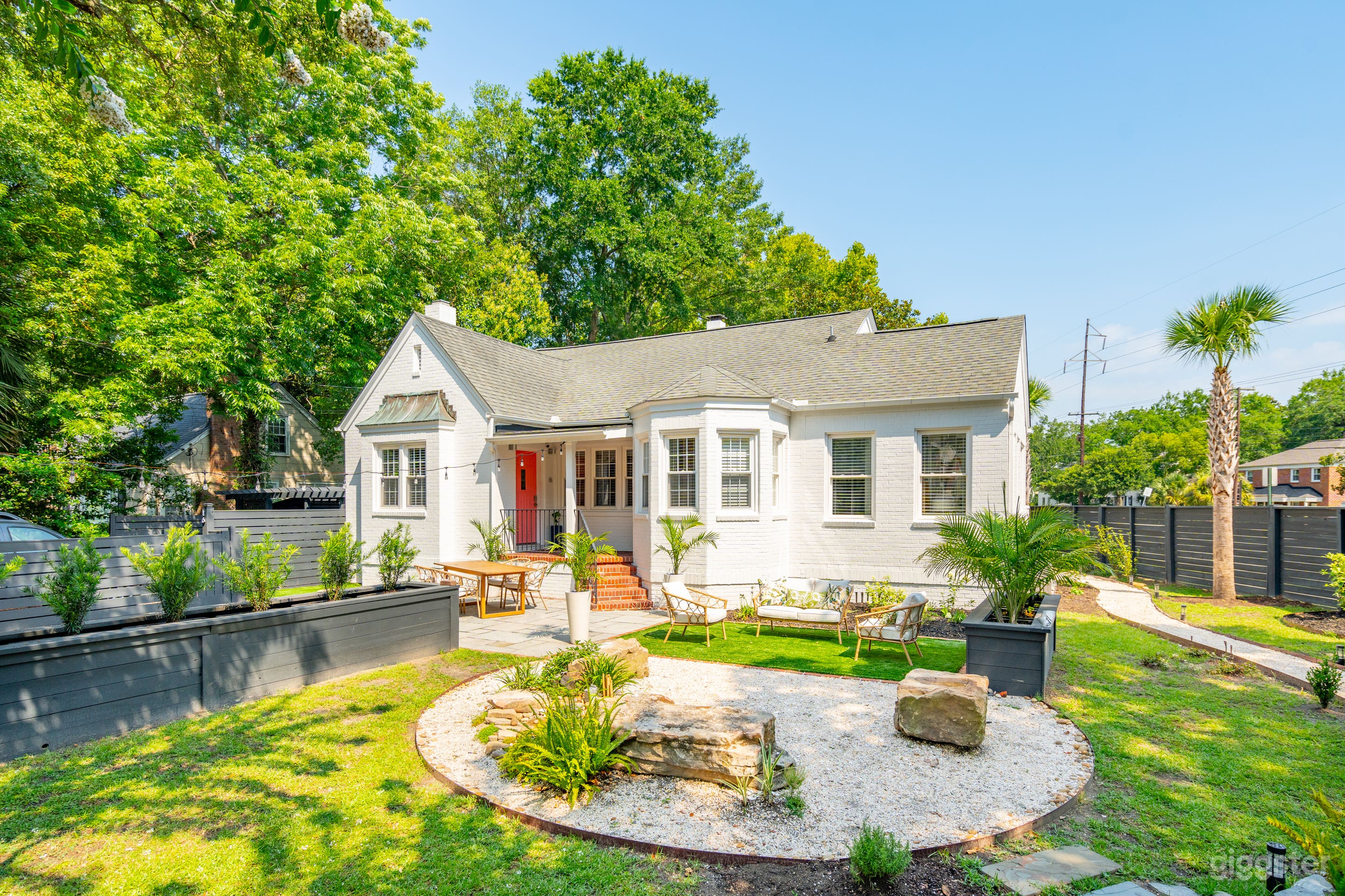 The Southern Zen™ front exterior with blue stone patio and artificial turf for entertaining and a Japanese inspired Zen garden including relaxing water features.