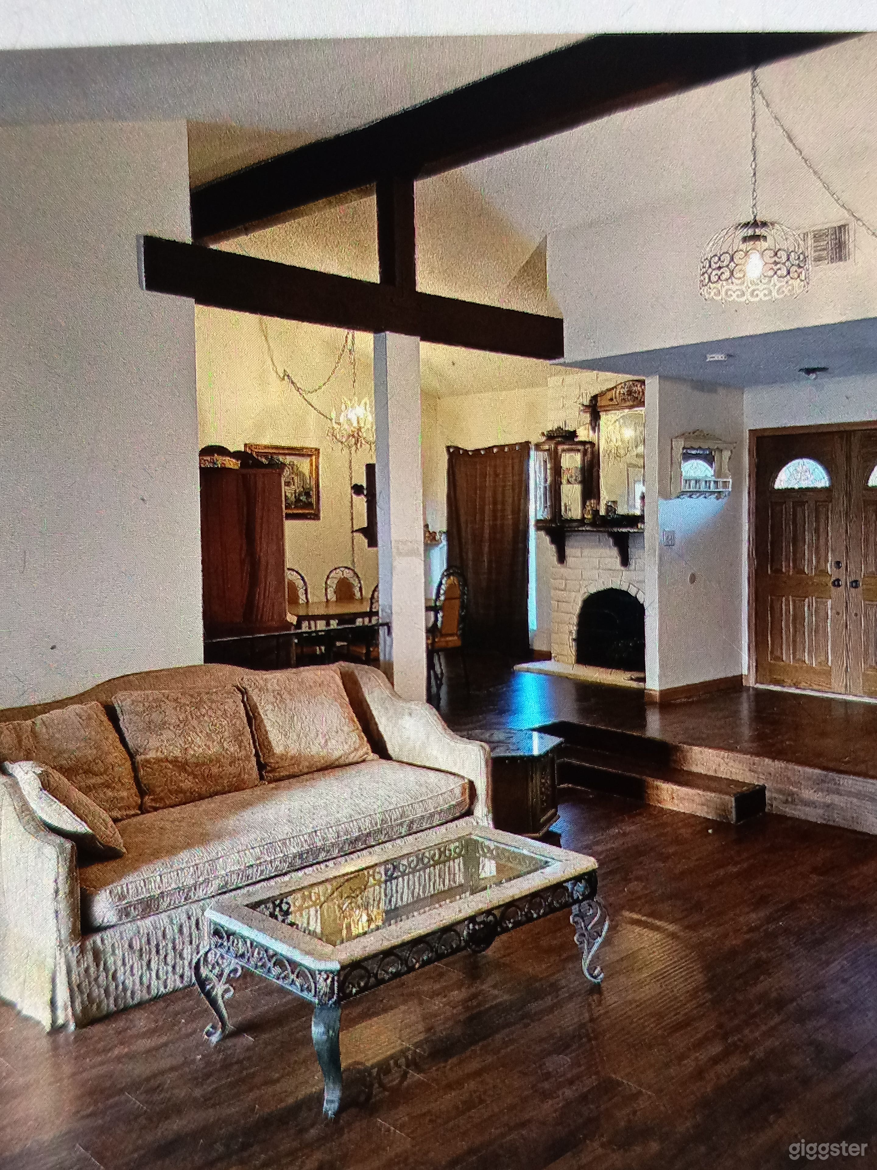 Dark green sofas, tan sofa and tiger print sofa can be swapped around as needed. Vaulted ceiling in living room with wood beams.