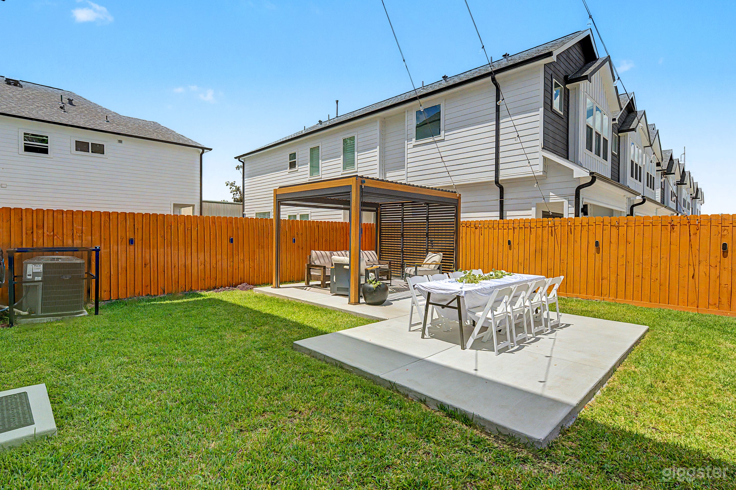 Large private backyard space with pergola lounge and dining area. Perfect for cozy meal or relaxing. Designed with versatility in mind, the dining area can be repositioned or removed to bring your vision to life.