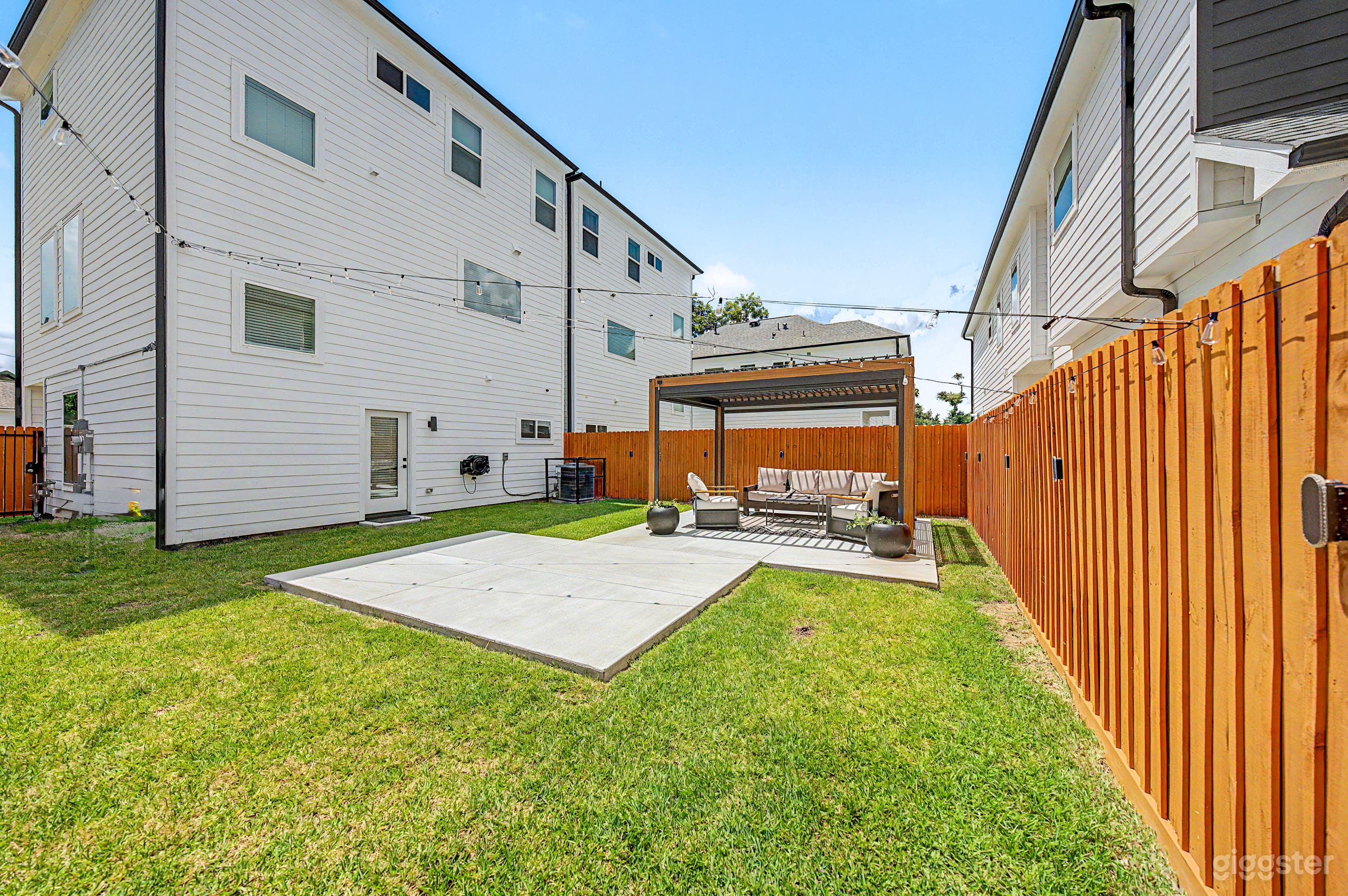 Large private backyard space with pergola lounge and dining area. Perfect for cozy meal or relaxing. Designed with versatility in mind, the dining area can be repositioned or removed to bring your vision to life.