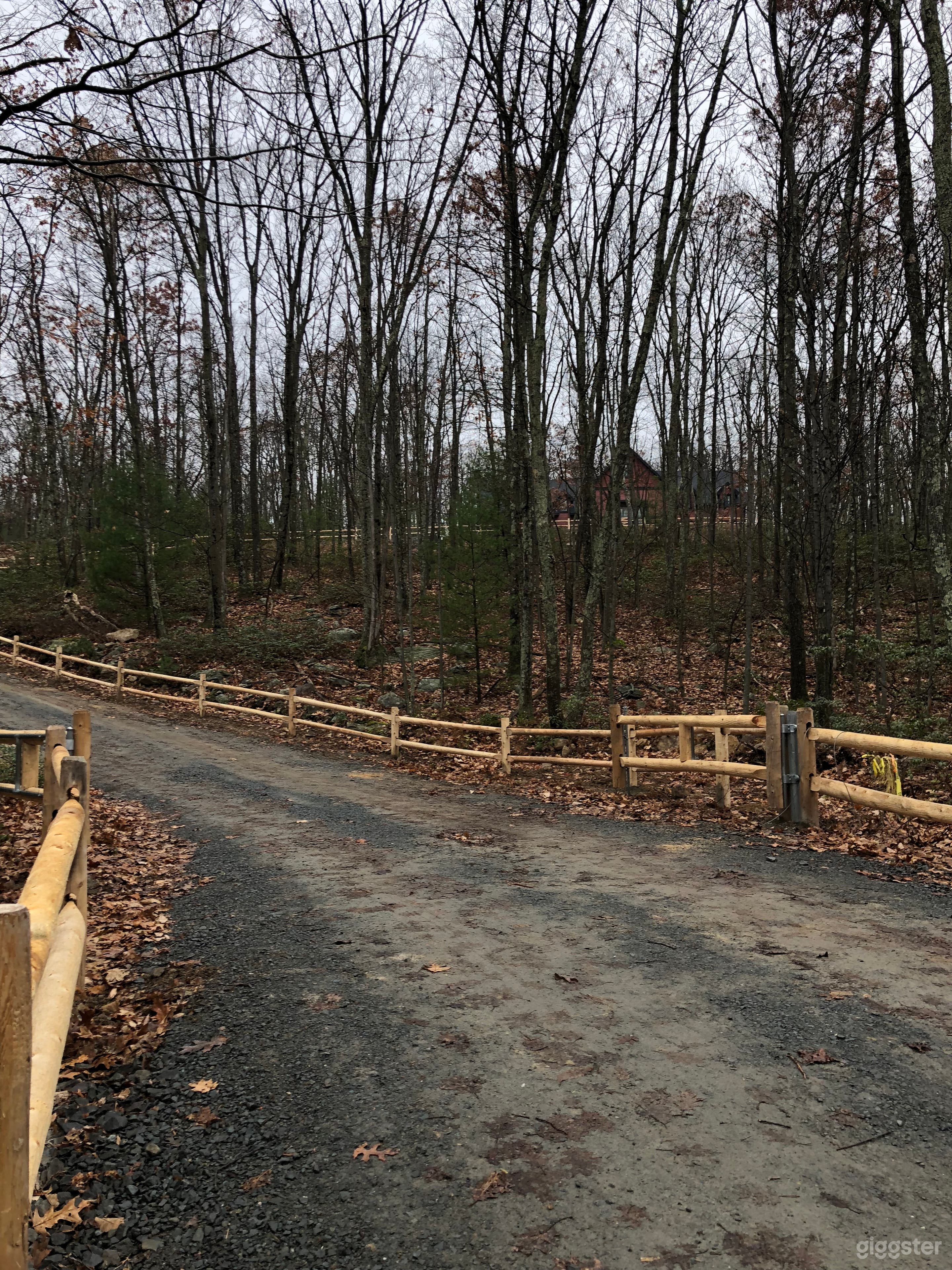 Wide gravel driveway with guardrails and plenty of space for large vehicles and additional parking if needed.