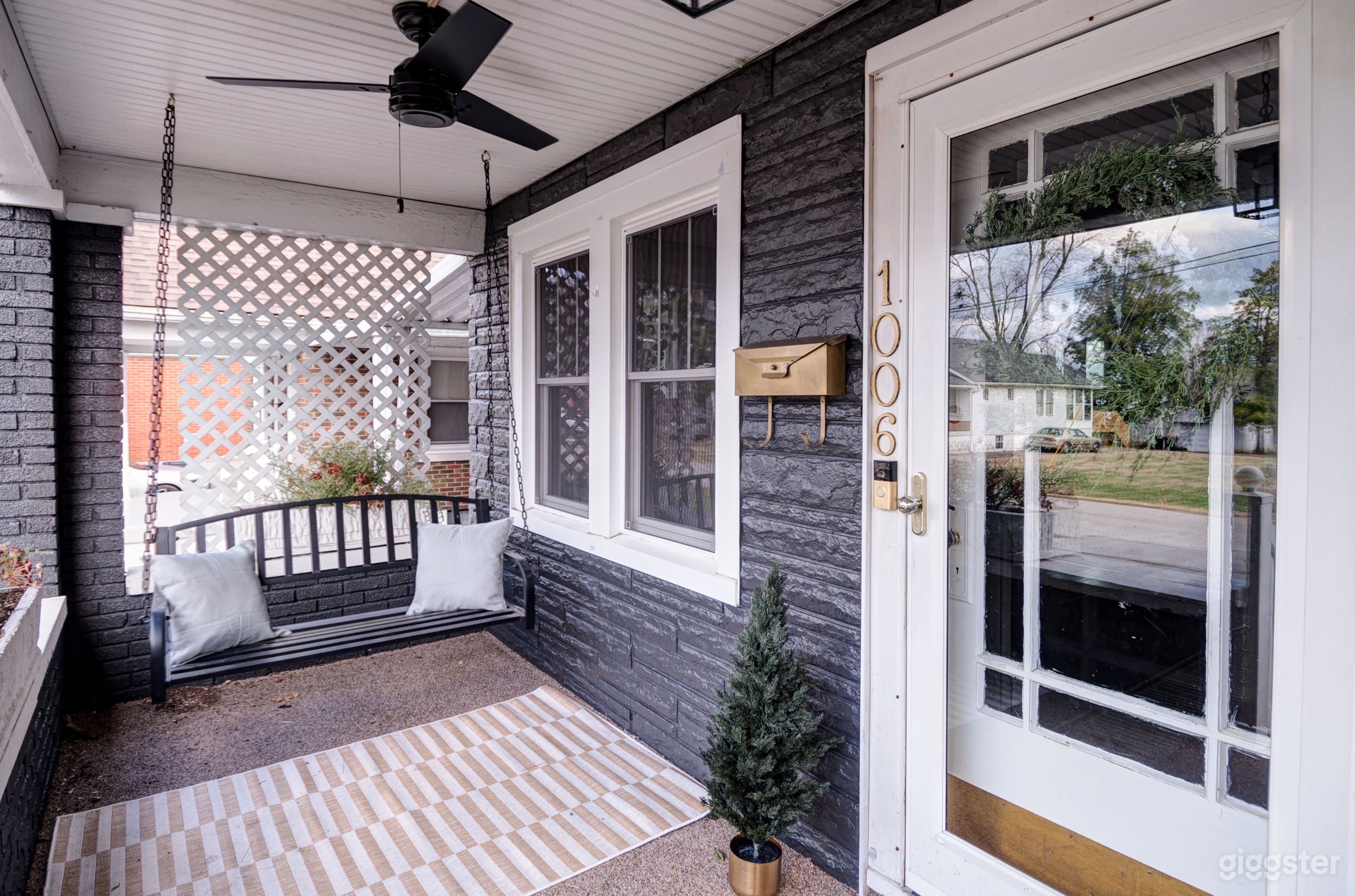 Covered front porch with brass details and a swing. Modern fan to help keep you cool! Relax outside with a cup of tea and listen to the church bell sounds in the distance. This neighborhood is quiet and family friendly!