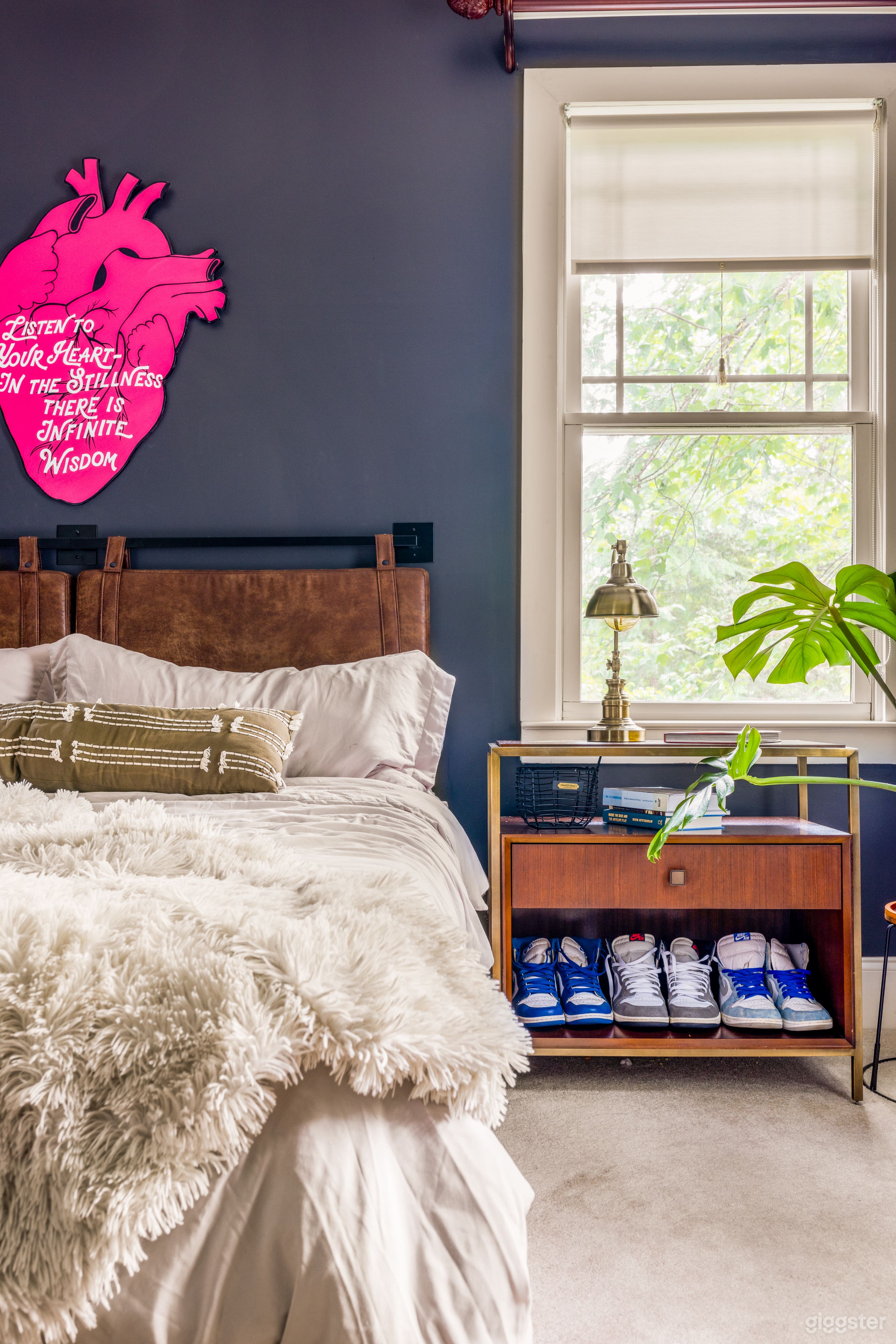 Stylish master bed room with fireplace and bed with leather headboard.