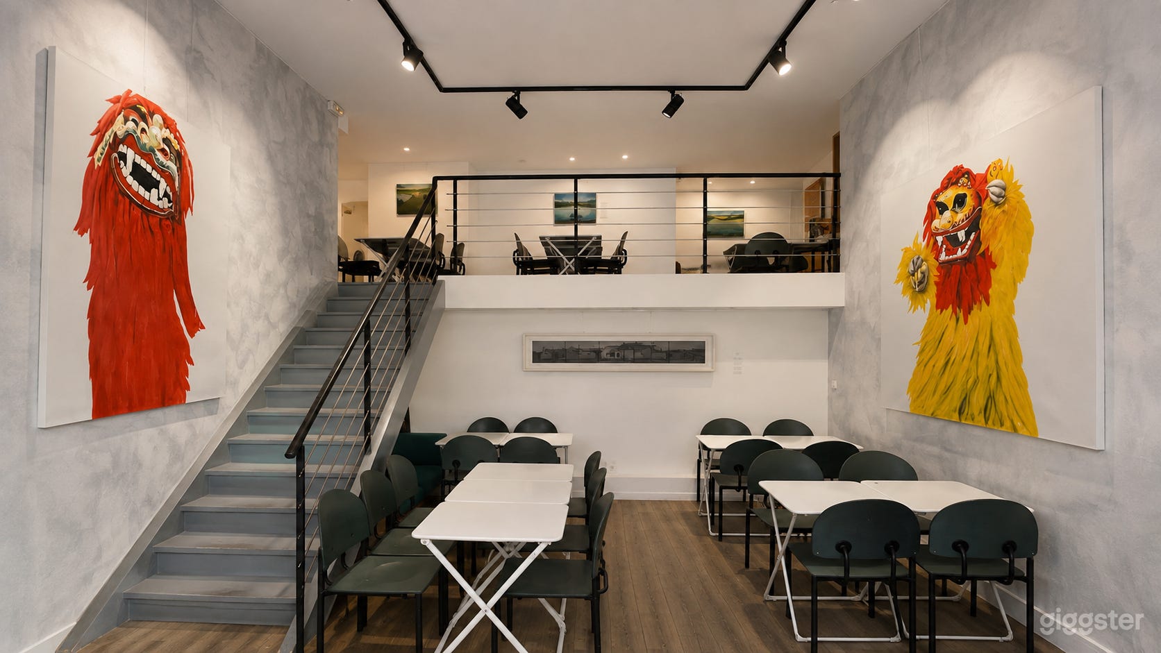 Galerie d'art à double hauteur et espace événementiel avec sièges en mezzanine.