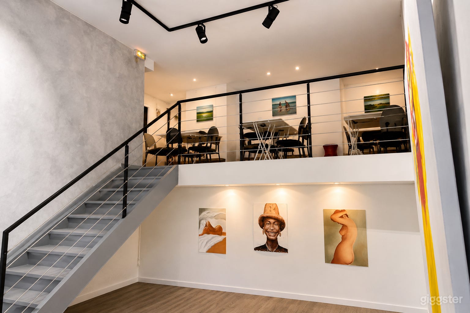 Niveau mezzanine surplombant le rez-de-chaussée, relié par un escalier ouvert et idéal pour des sièges de groupe ou des configurations plus petites.