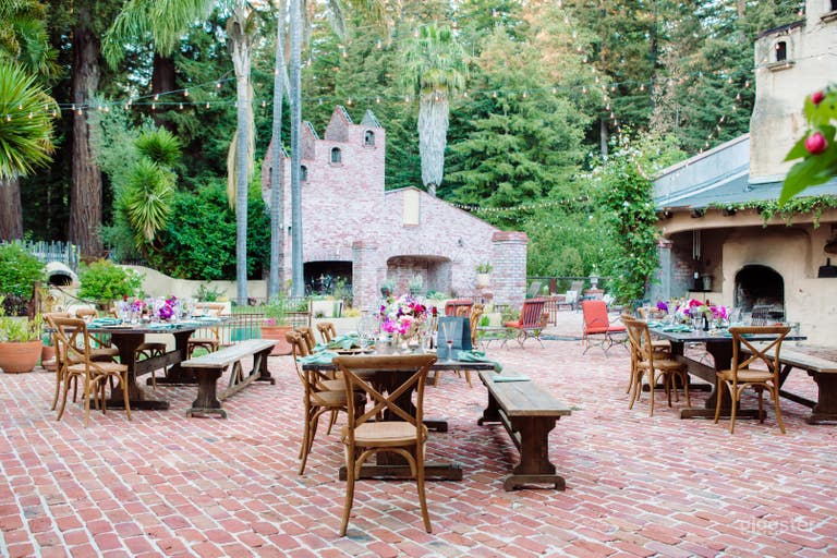  A large, expansive brick courtyard with an oversized tiled swimming pool and two fireplaces. 