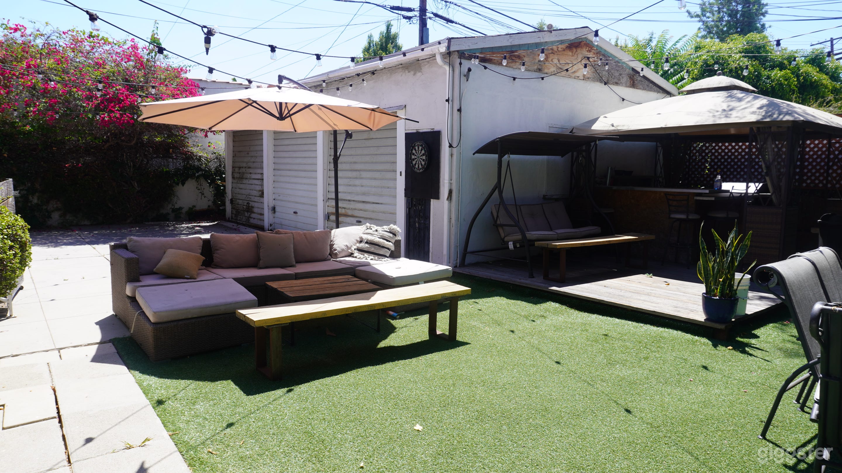 Backyard with string lights and outdoor bar and plenty of seating. 