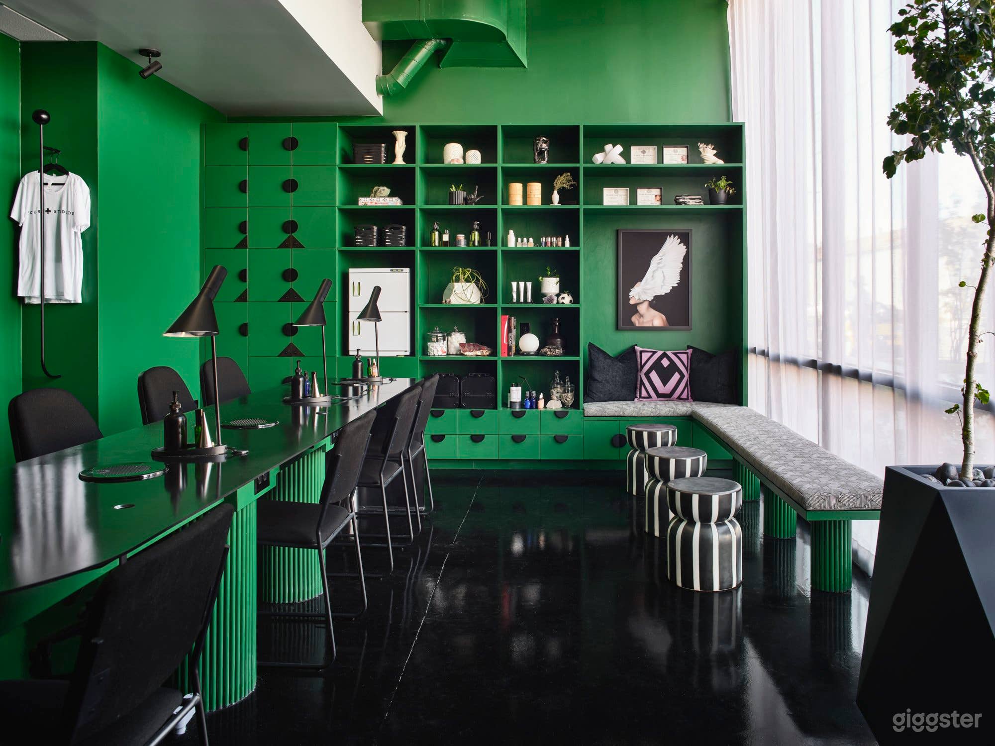Floor to ceiling north facing windows pull in a ton of natural light Vibrant green walls, high gloss black epoxy floors. Built in shelving can be rearranged for shoot specific needs. 