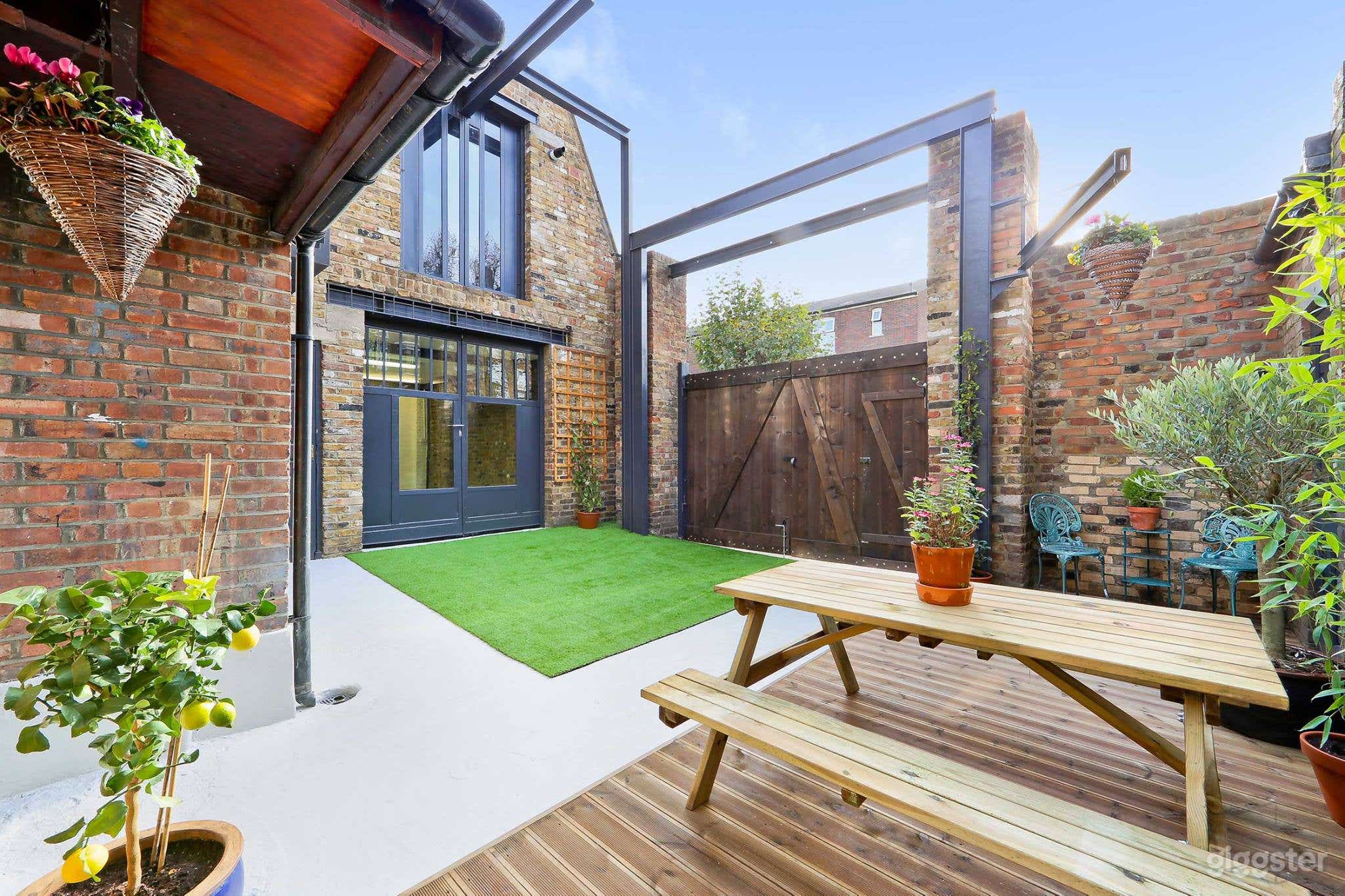 A courtyard sits outside with a patio and outdoor table.