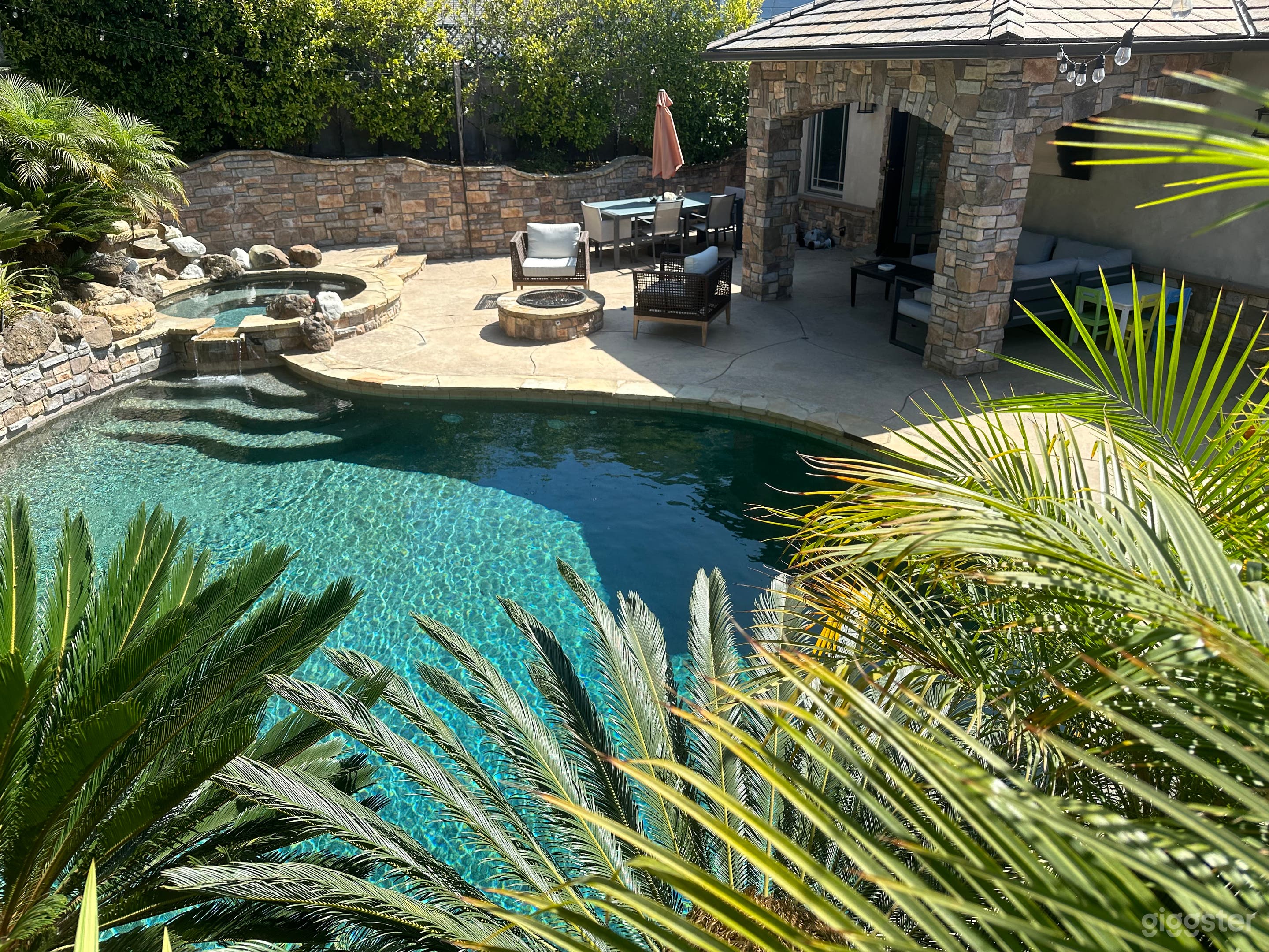 Resort-like backyard with pool, jacuzzi, 3 waterfalls, covered seating, fire pit, outdoor bbq and bar.
