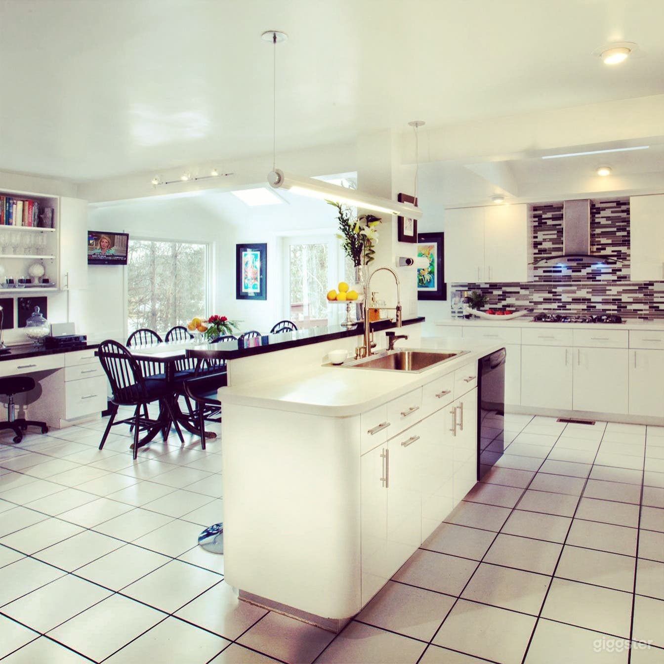 Large, white, open floor plan kitchen with island seats 10 at table plus 2 at counter