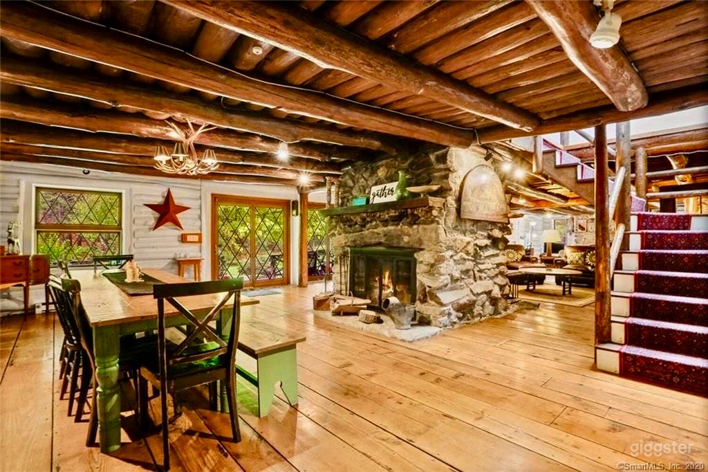 Dining area with charming log cabin stairs case leading to four bedrooms and three baths on second floor.