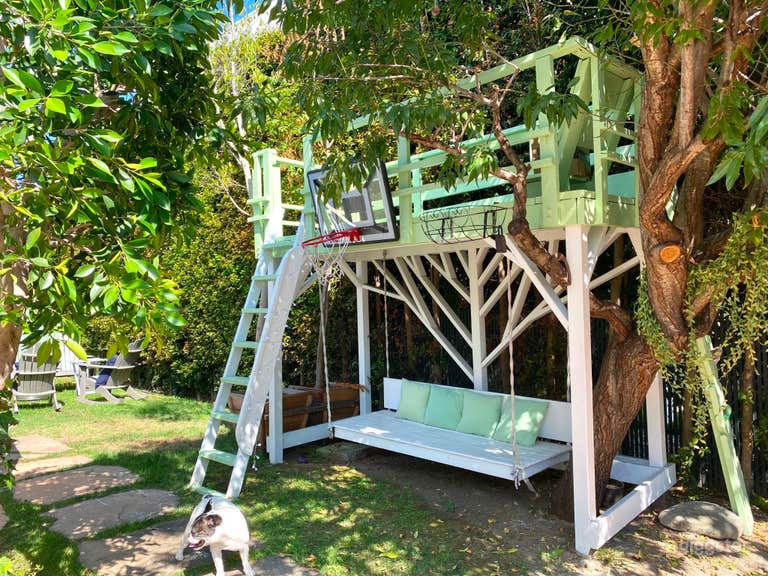  Enchanting Spanish-Style Home with Lush Greenery and Treehouse 