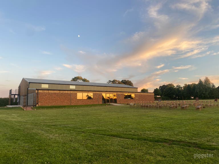  The Tractor Barn front- brick building, windows, green corrugated metal, black industrial  