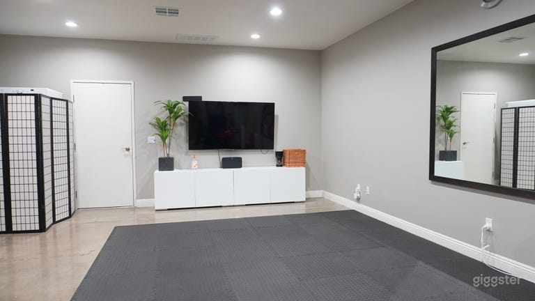  Gym space with large television, mirror and exercise equipment. 