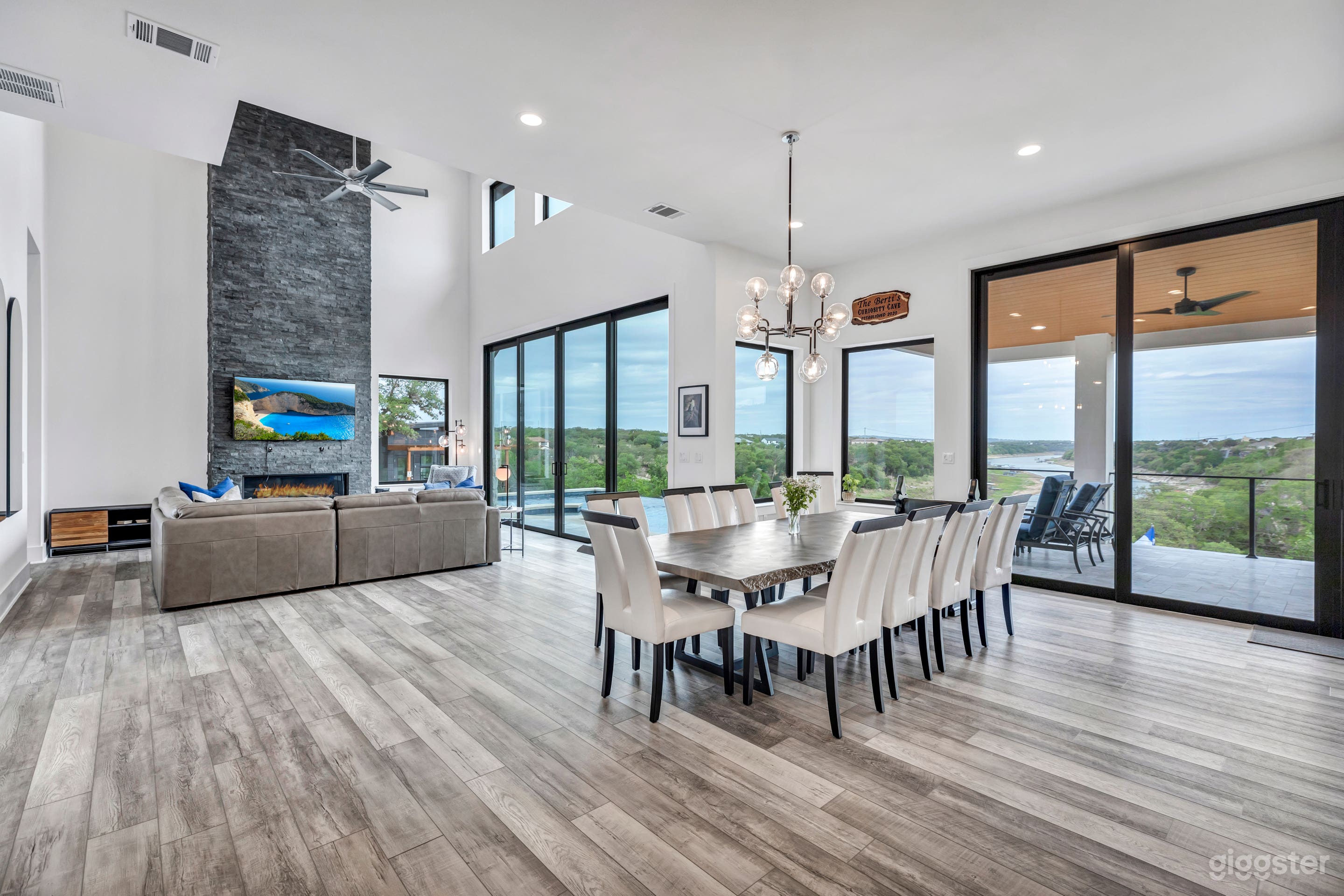 12ft ceilings in the kitchen and dining area expand into the two story open livingroom with floor-to-ceiling black stone fireplace that starts with a light switch. Wood slab dining table seats 11.