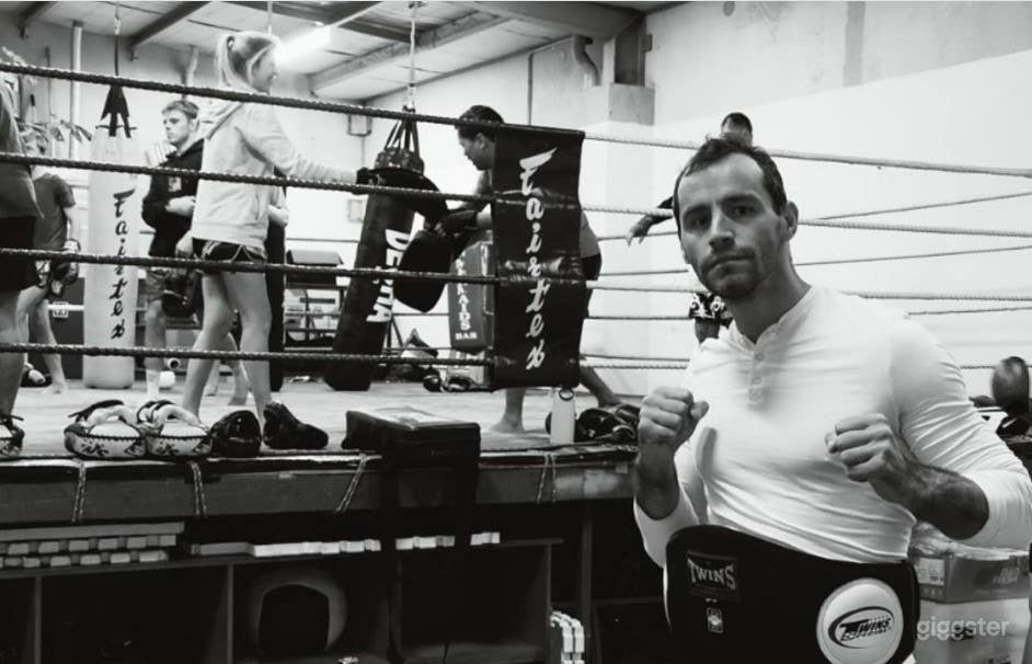 Coach and students training in the full competetion sized boxing ring and padded strength and conditioning area.