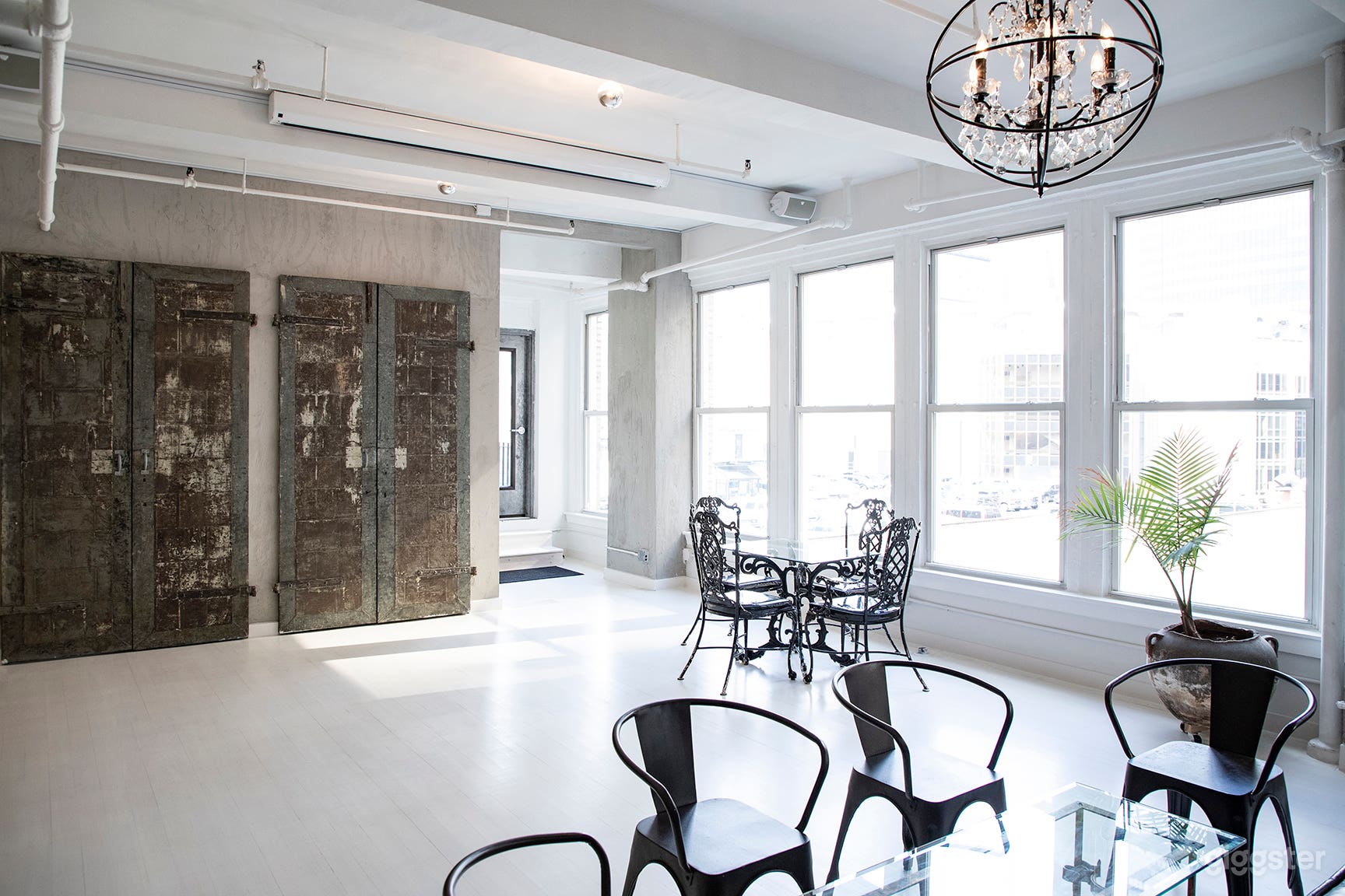 - Wall of windows that pour in natural daylight
- White stained wood floors
- Exposed concrete walls 
- 100+ year old vintage metal doors