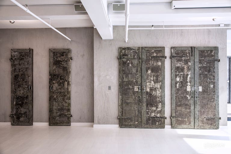  - White stained wood floors
- Exposed concrete walls 
- 100+ year old vintage metal doors 
