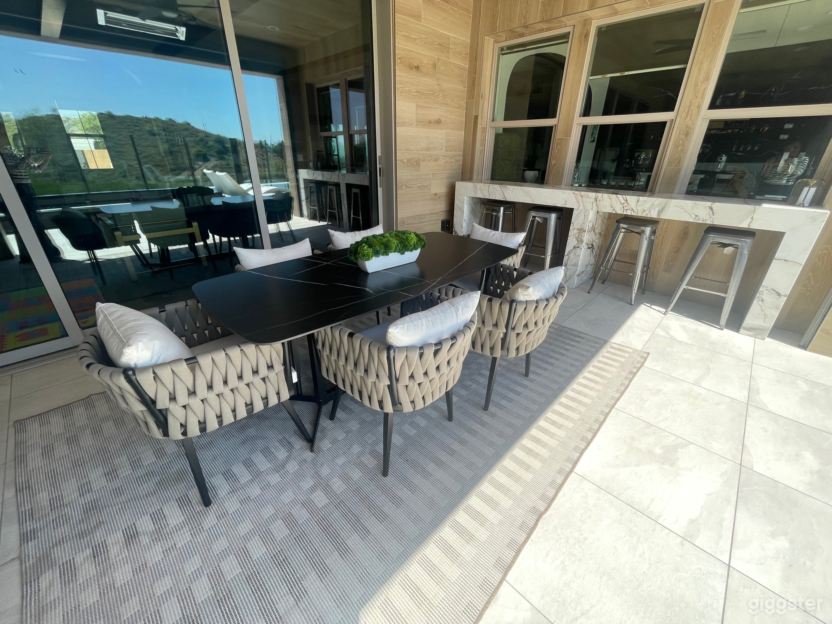 outdoor dining room table and 6 chairs with bar behind it 