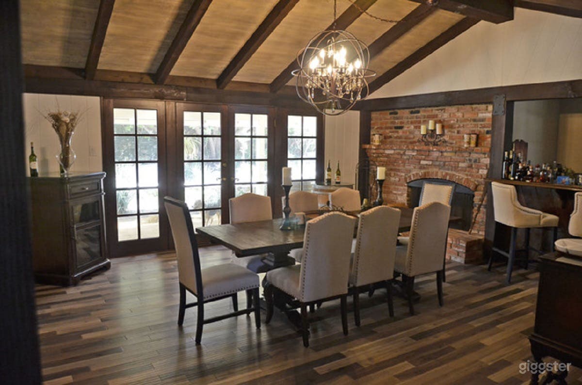 Dining Room with brick working fireplace, bar and french doors leading to charming patio area 