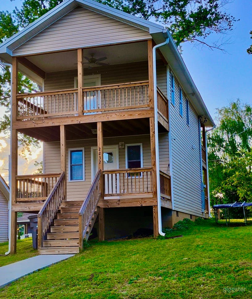Rear of house with wide porch and balcony. 