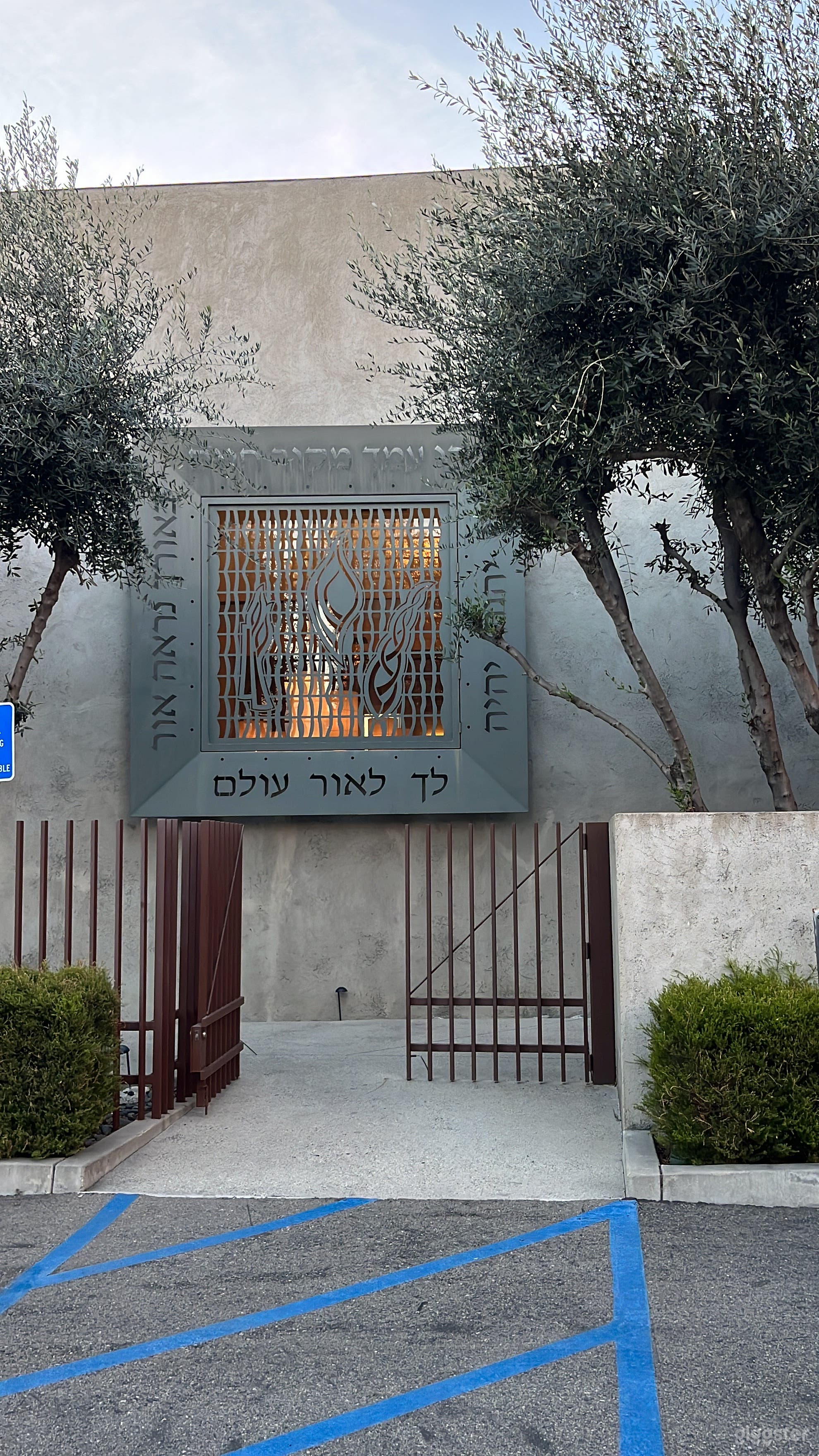 Gated entry to small temple courtyard with fountain and large entry door.