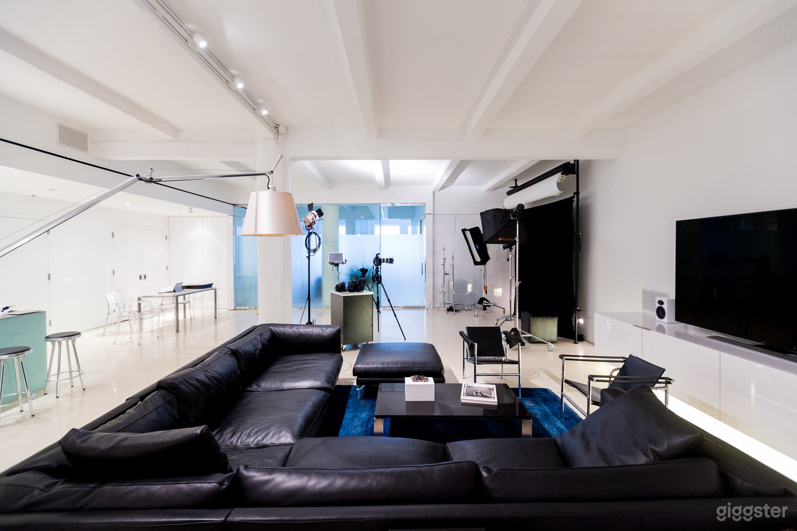 View of the Media Area with seating for 9 ppl possible.  Exquisitely luxurious custom leather couch and ottoman.  Eames Recliner, and 2 leather chairs.  Eileen Gray glass endtable.  Custom black granite coffee table.