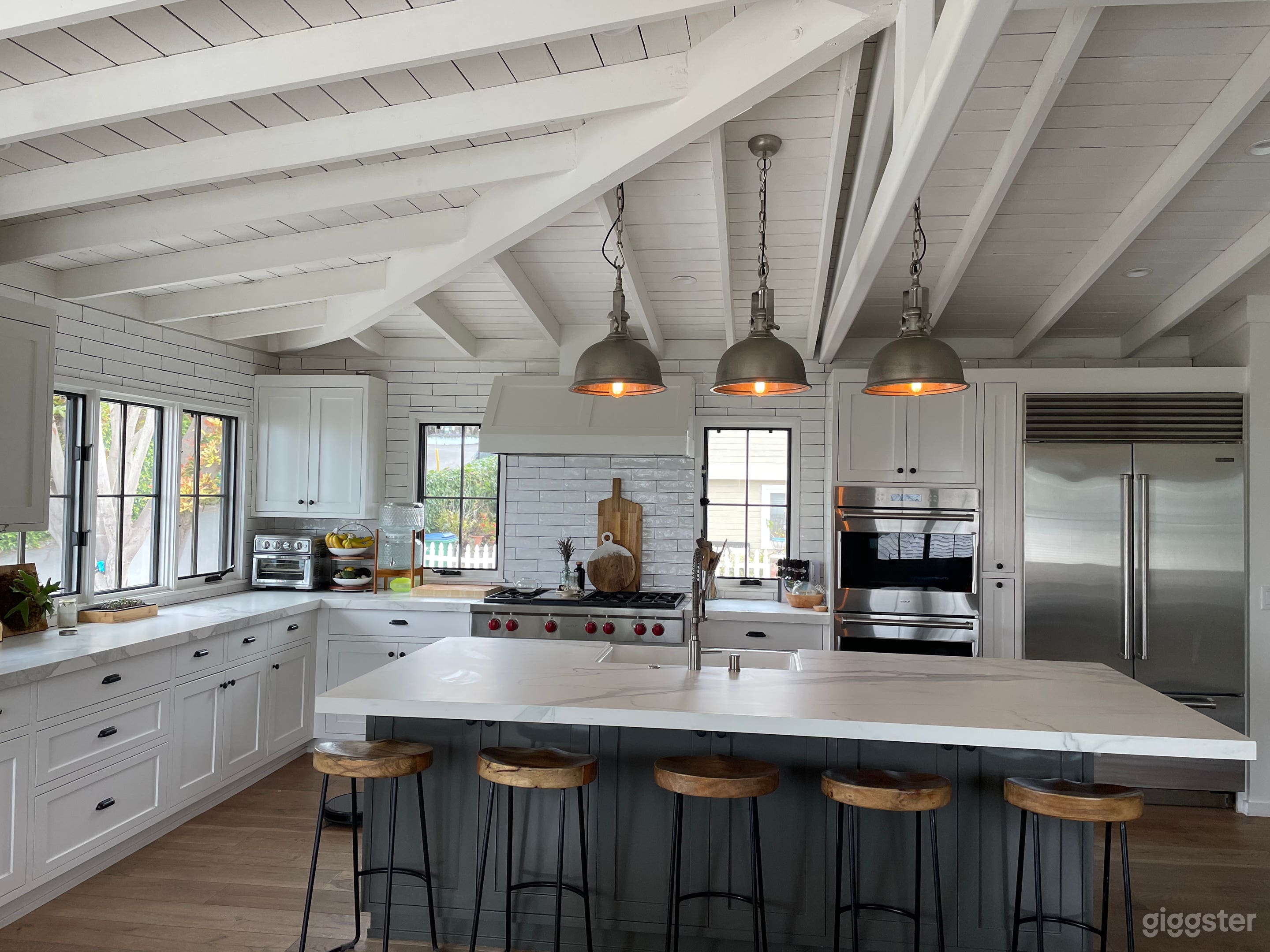  Farmhouse Kitchen Sink, huge Island, Rustic Wood flooring, Stainless steel appliances and large picture windows.