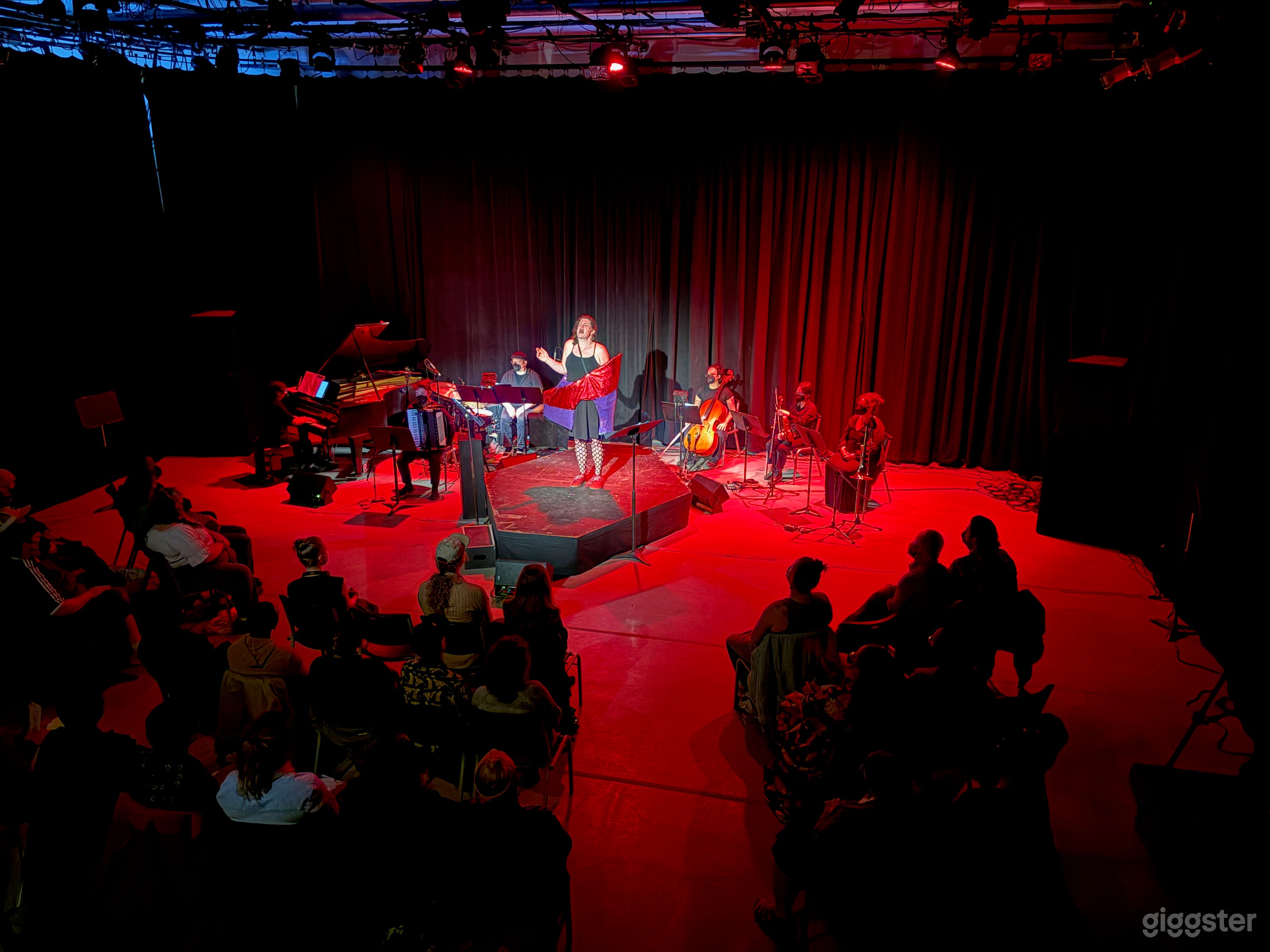 Music theater performance with rear black curtains close and platforming from the venue
