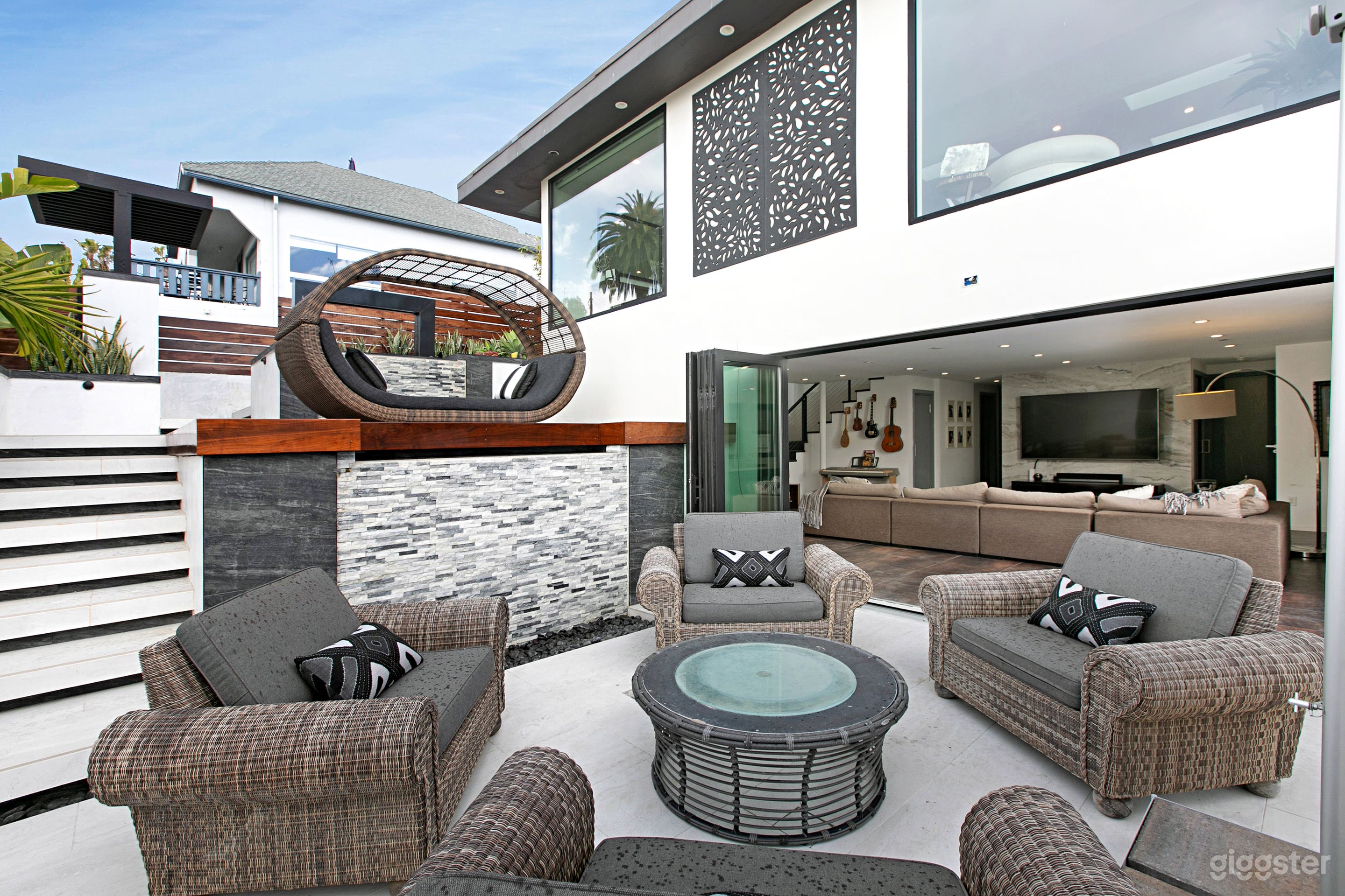 Front yard of house. There is a modern spa to the right and a view of the beach/ocean