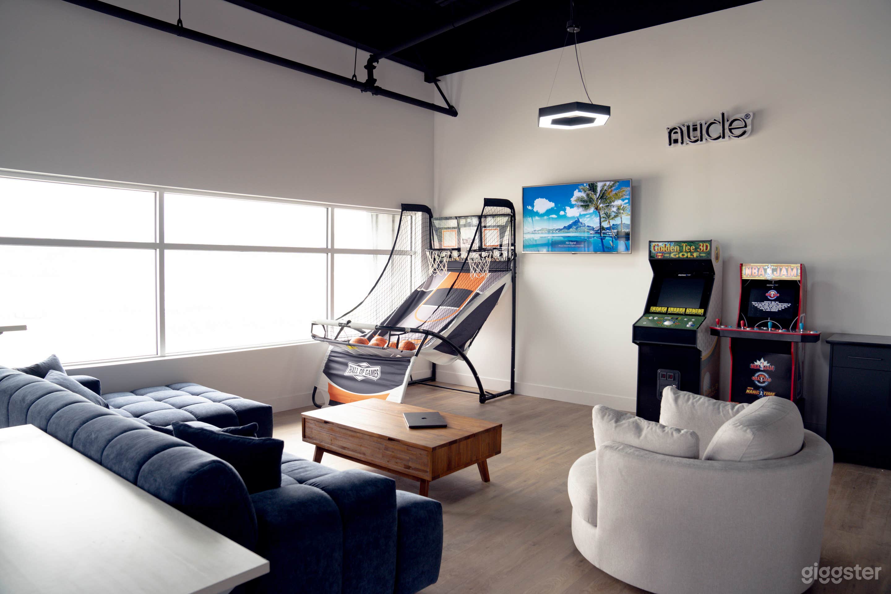 A different view of our lounge area that includes a modern, blue, sectional couch and large swivel chair.