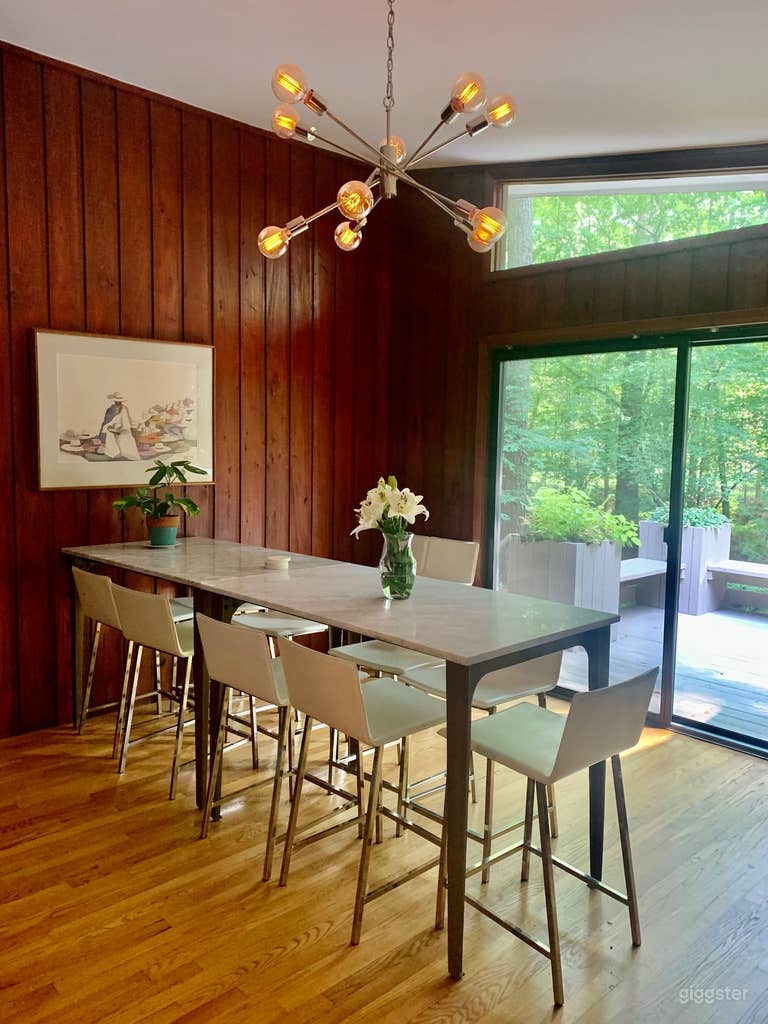  Cabin vibes meet mid-century modern meet formal yet playful luxury in this dining room. There&#x27;s seating for 9 at these CB2 marble high top dining tables with CB2 white leather chairs. Located between the kitchen and one of two entrances to the deck 