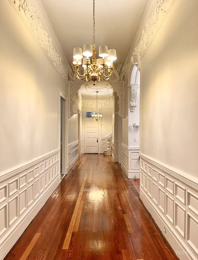  first floor center hall facing grand staircase. Behind the door are 3 bathrooms, two staging areas, butler&#x27;s pantry, and entrance to courtyard 
