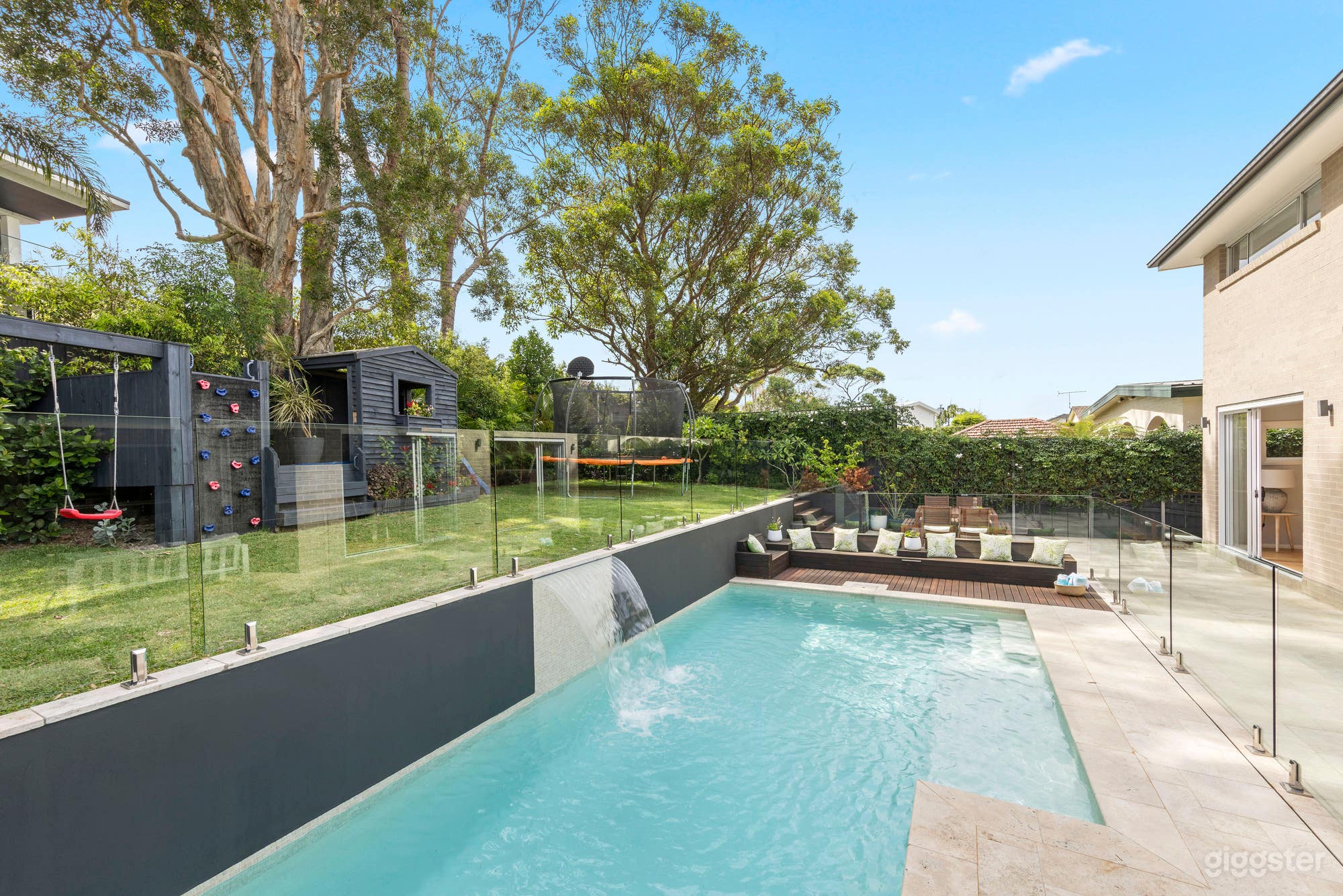 Outdoor heated pool with seating, waterfall and lighting