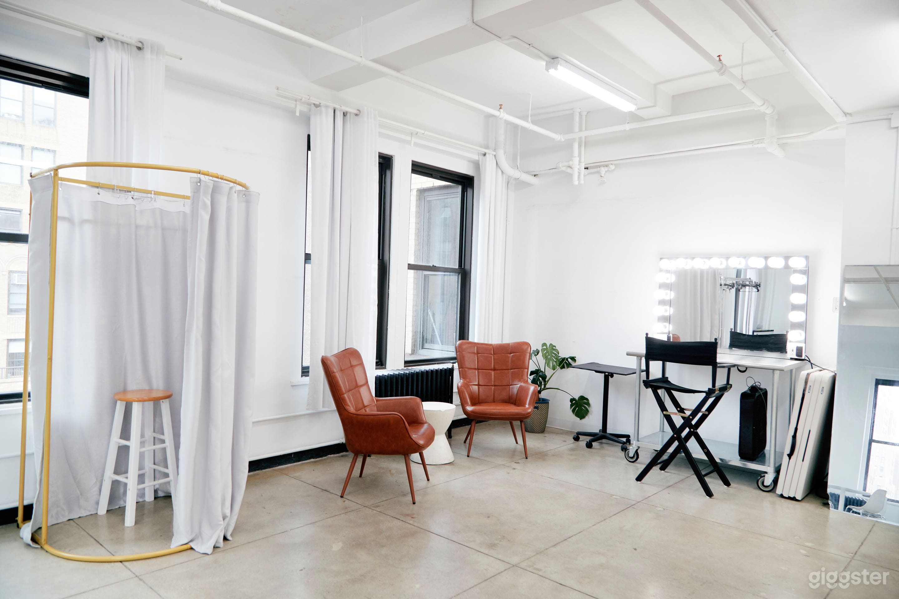 Studio A is equipped with one makeup station, a changing room. 2 clothing racks, two brown chairs and a dark brown sofa. 