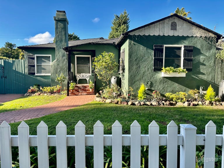  Exterior landscaping includes white picket fence with aged-brick pathway and driveway. Original white scalloped roofline trim and window box with flowers add to the cottage feel! 