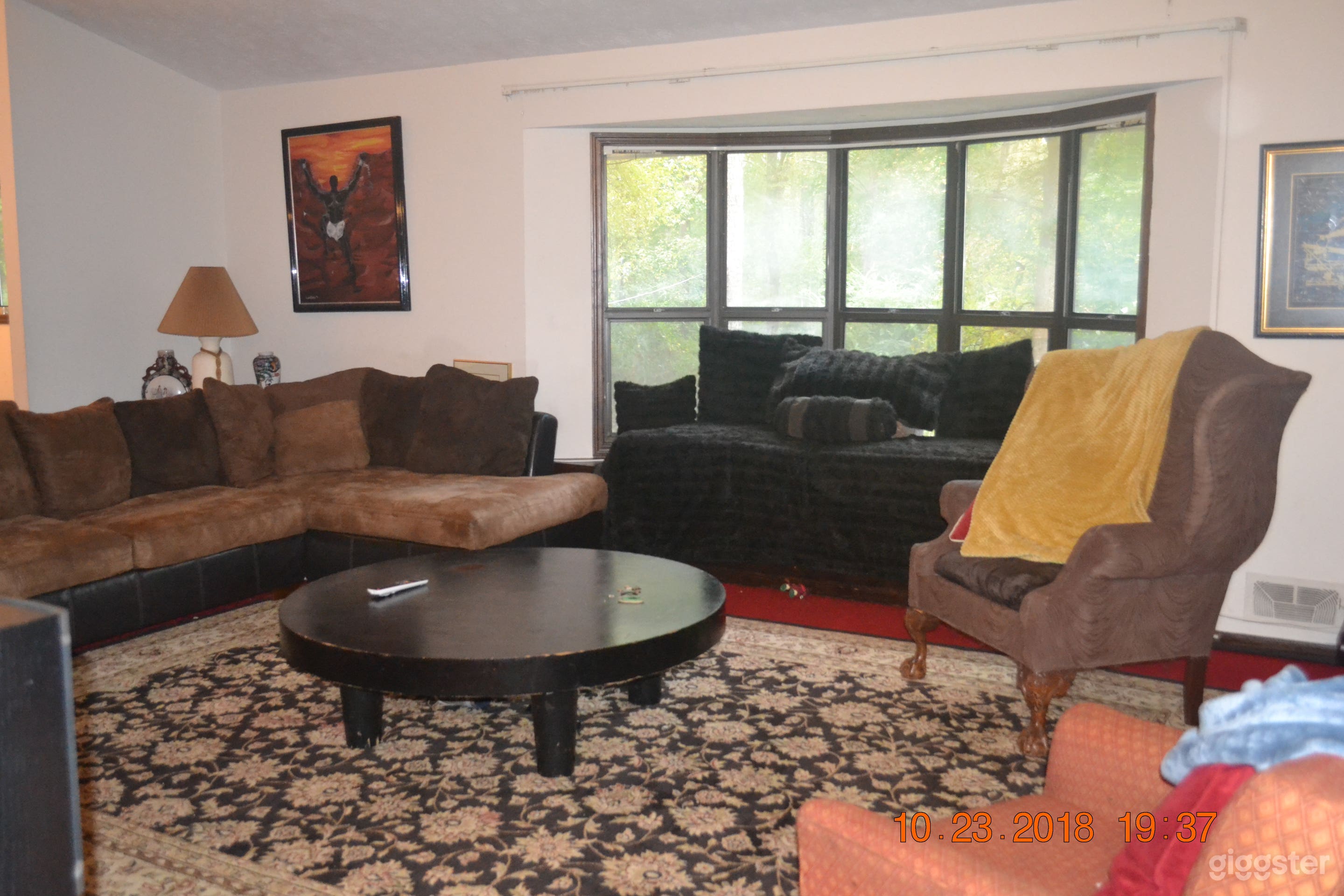 Family room with large bay window, bench, storage spot.