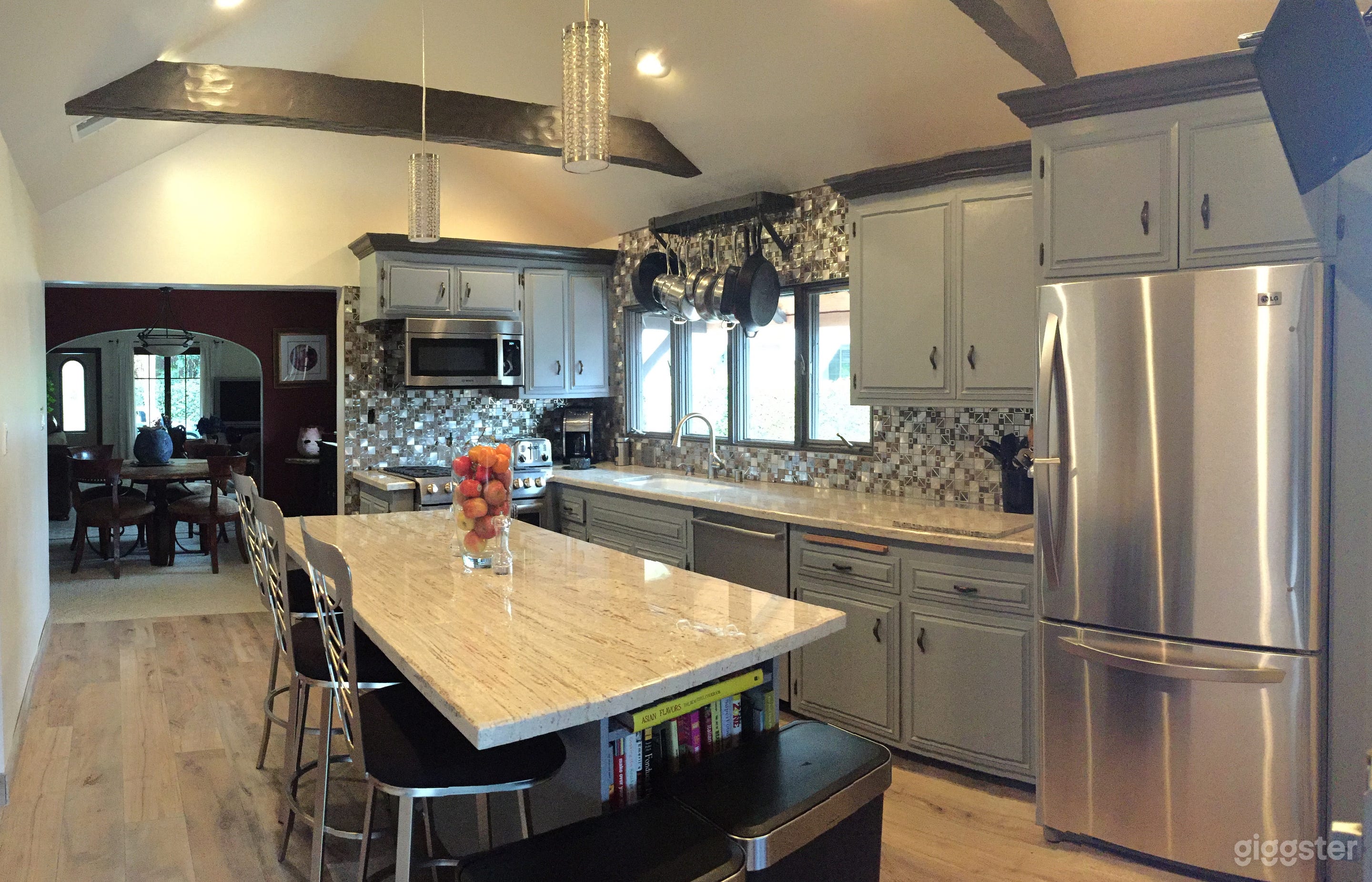 Kitchen with vaulted ceiling, marble countertops, island and long-shot view to entrance.