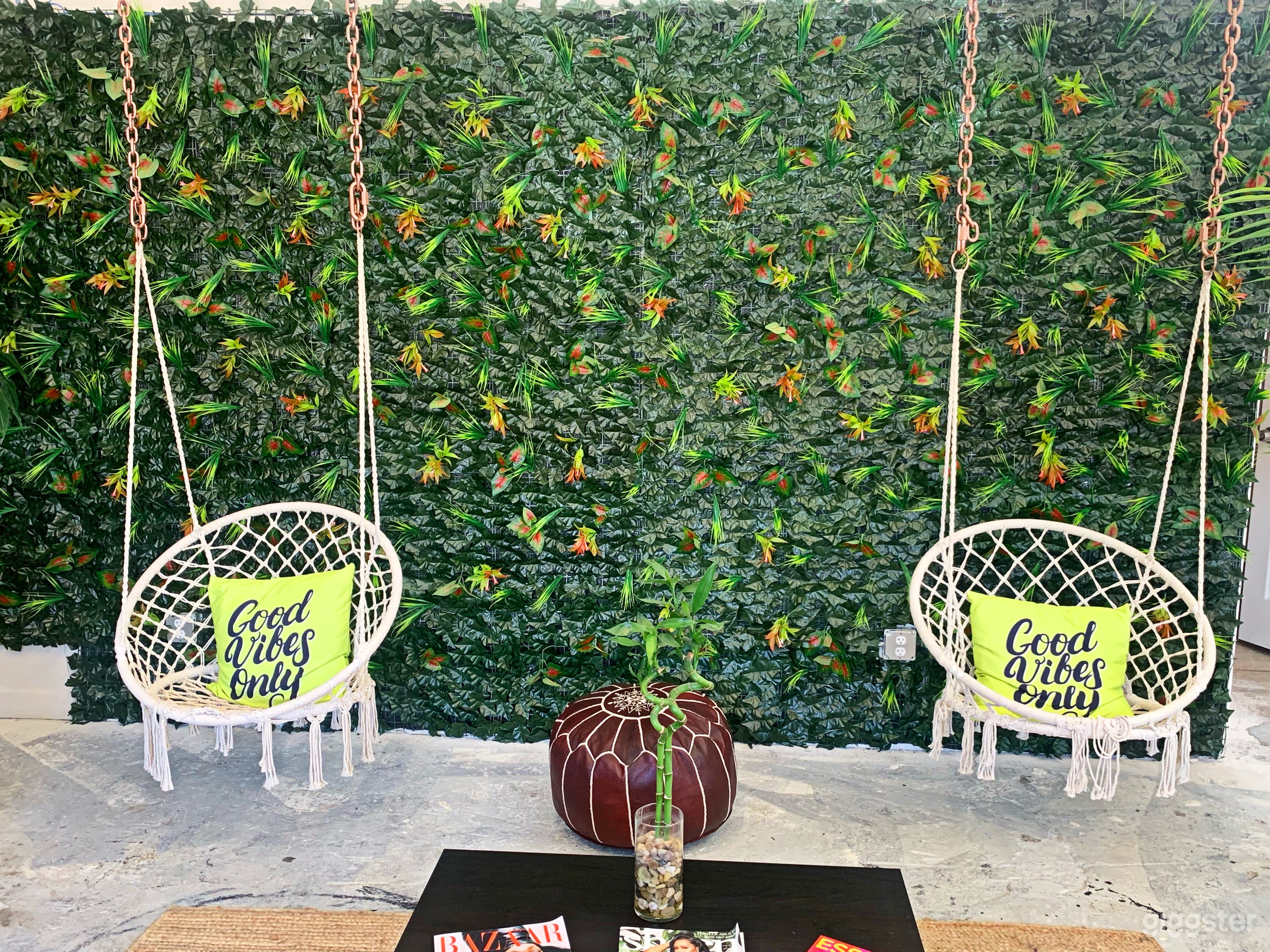 Custom Lounge area  displays a one of a kind tropical green wall with comfortable hammock swings for photo opportunities.