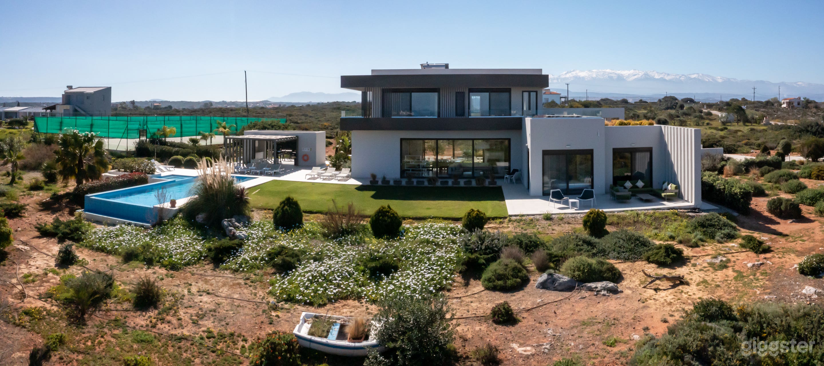 Exterior with infinity pool and private tennis court