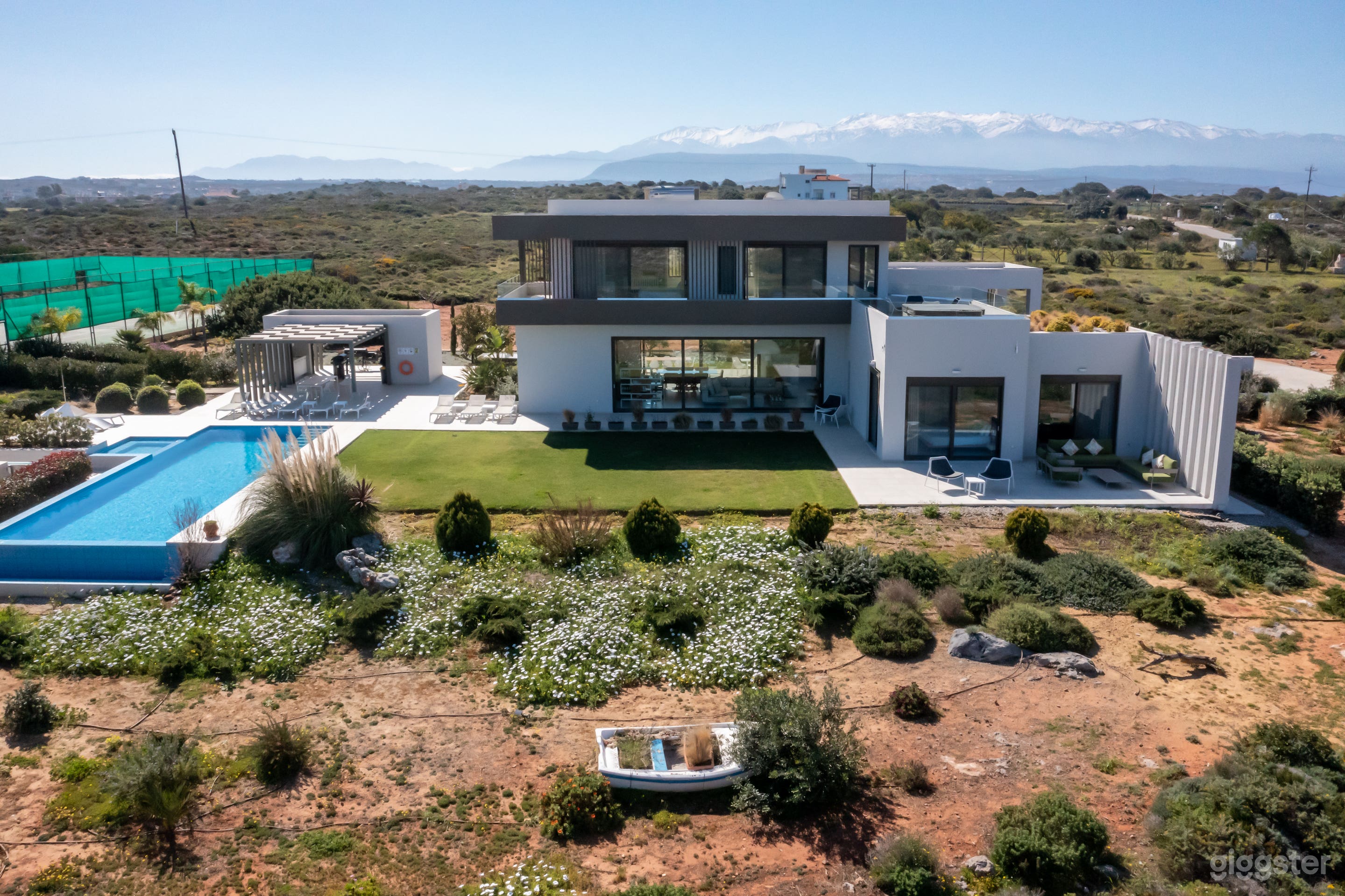 Exterior with infinity pool and private tennis court
