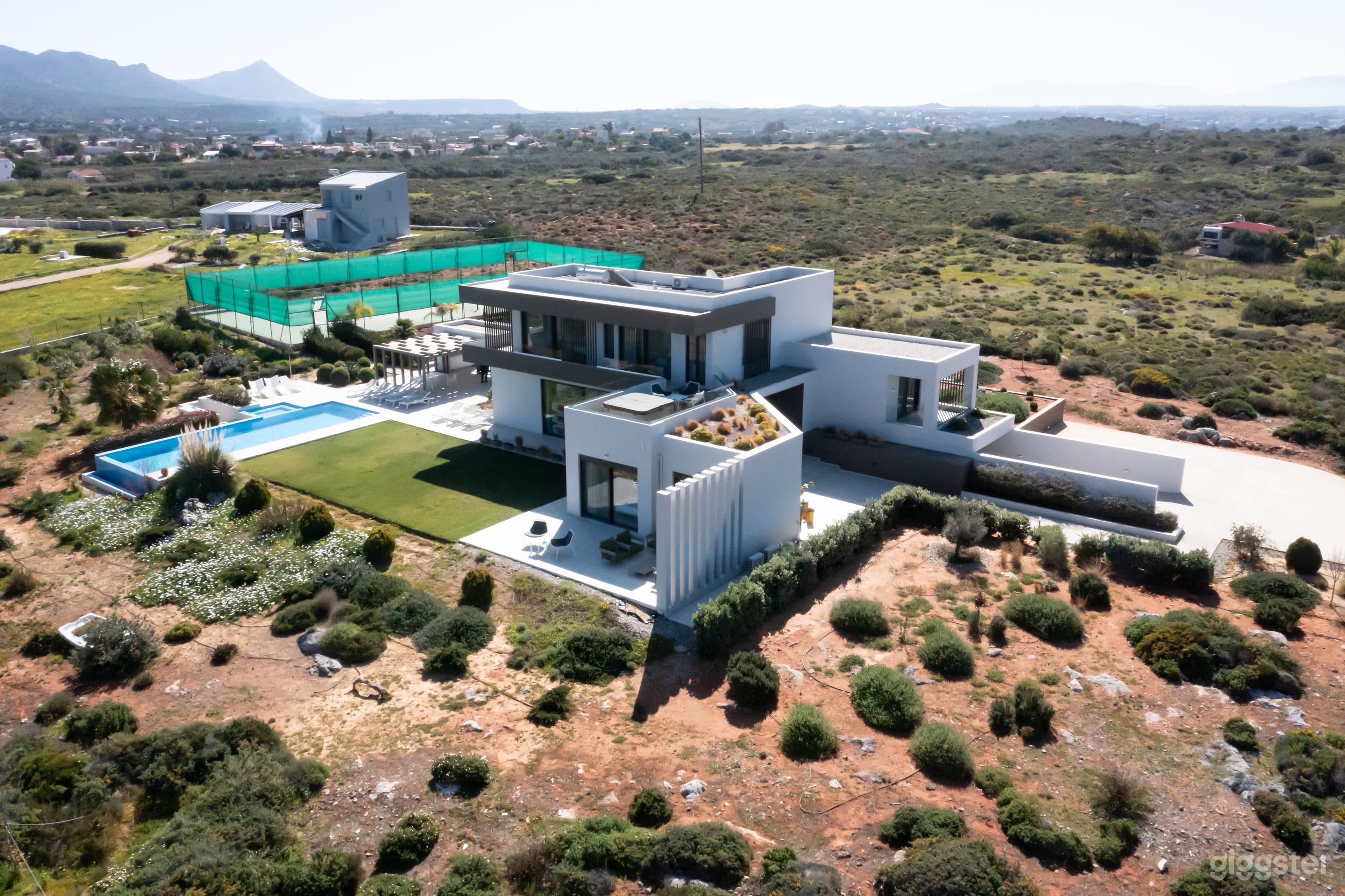 Exterior with infinity pool and private tennis court