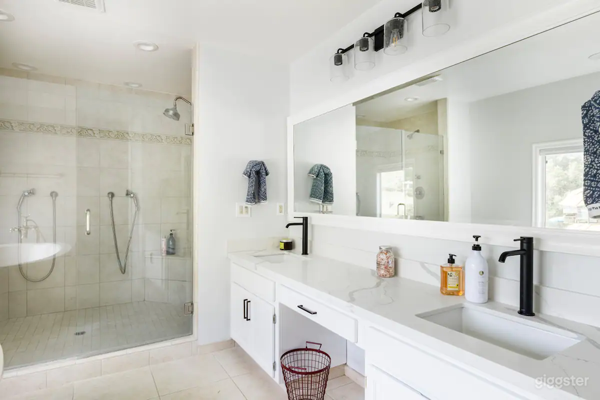 Primary suite bathroom with double sinks, double shower, and soaking tub